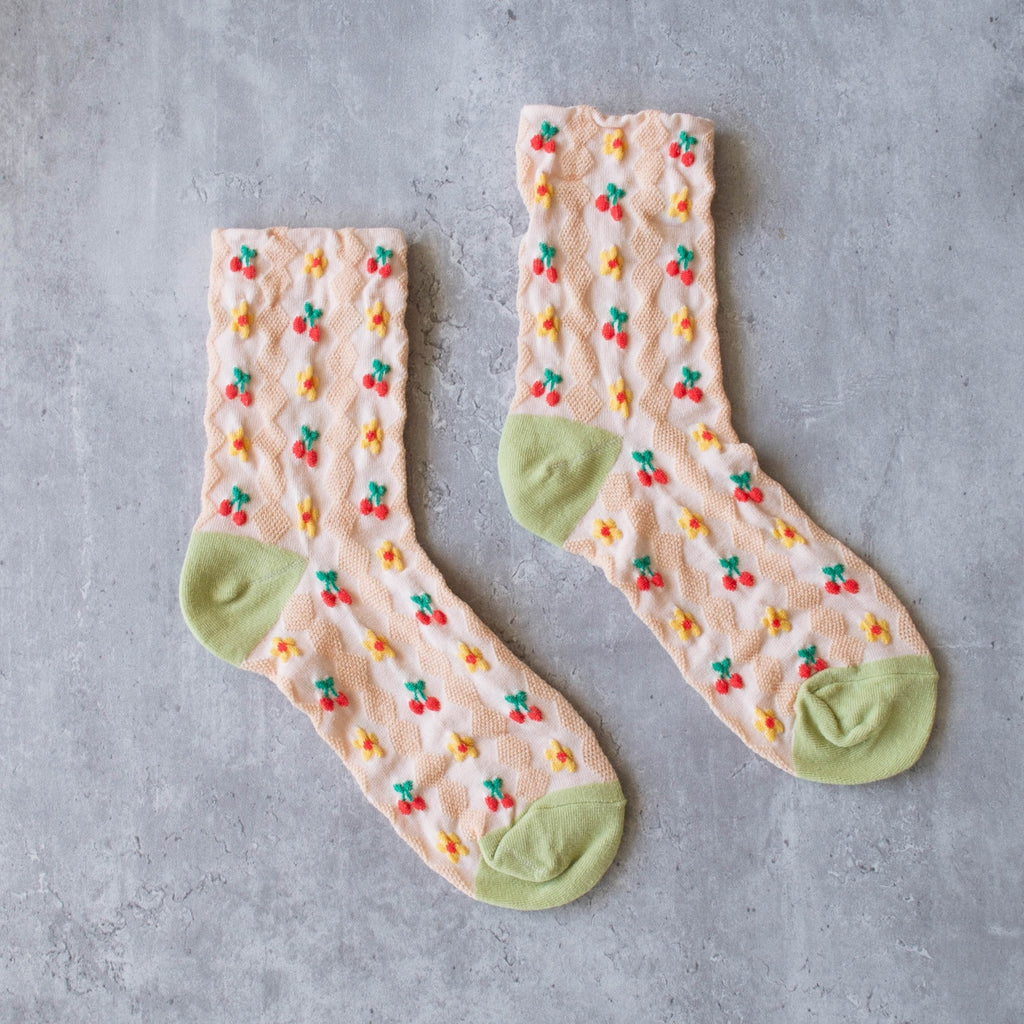 Introducing our new Cherry Floral Pattern Socks! Made with a blush base, these crew socks feature a dainty cherry and floral pattern that adds a touch of sweetness to any outfit. Stay comfortable and stylish with these must-have socks.