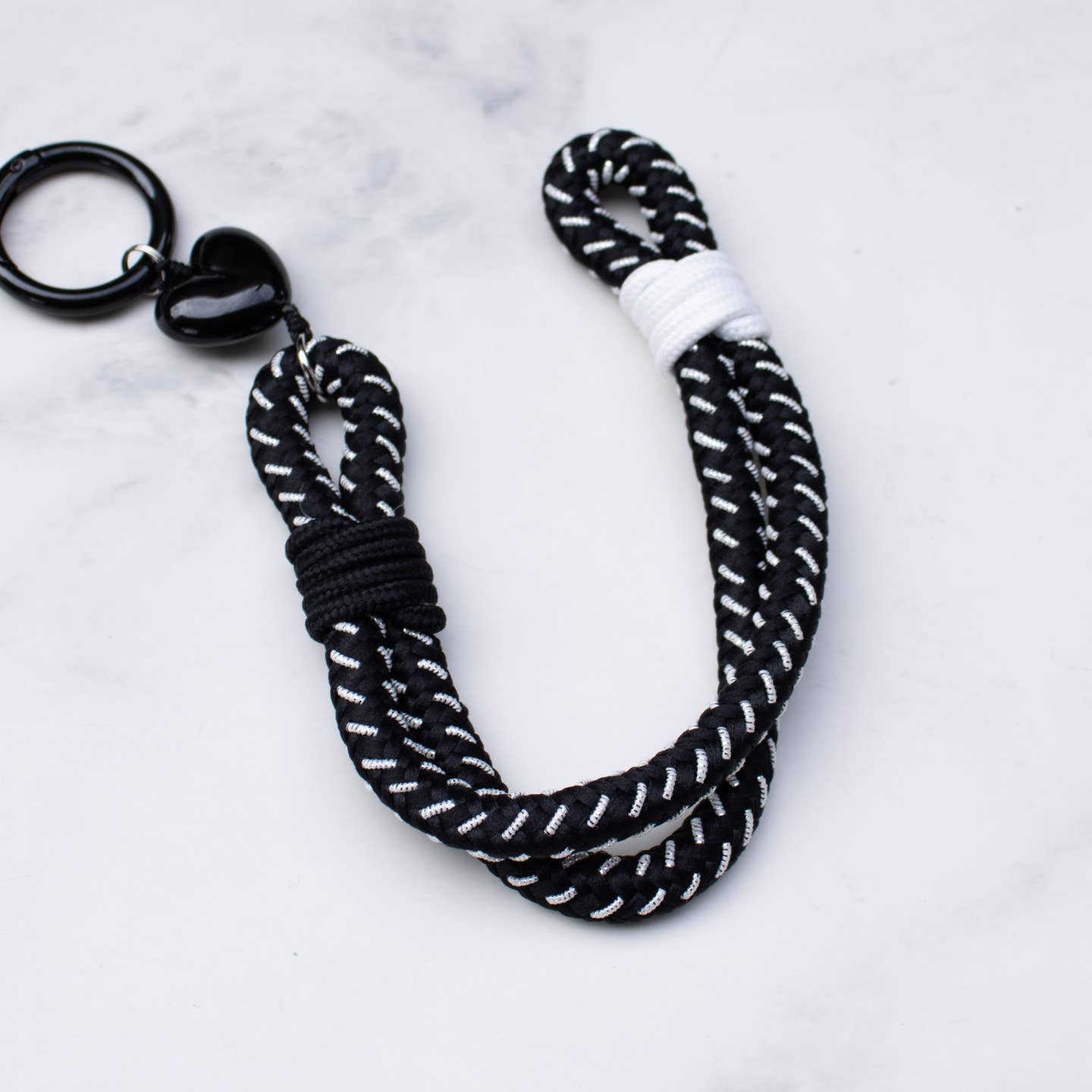 This versatile rope keychain features a charming heart charm and can also be used as a stylish bag accessory. The durable design is perfect for holding all of your keys securely, while adding an elegant touch to your everyday essentials. Keep your belongings organized and fashionable with this must-have accessory.