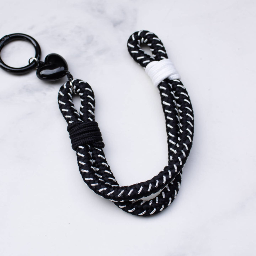 This versatile rope keychain features a charming heart charm and can also be used as a stylish bag accessory. The durable design is perfect for holding all of your keys securely, while adding an elegant touch to your everyday essentials. Keep your belongings organized and fashionable with this must-have accessory.