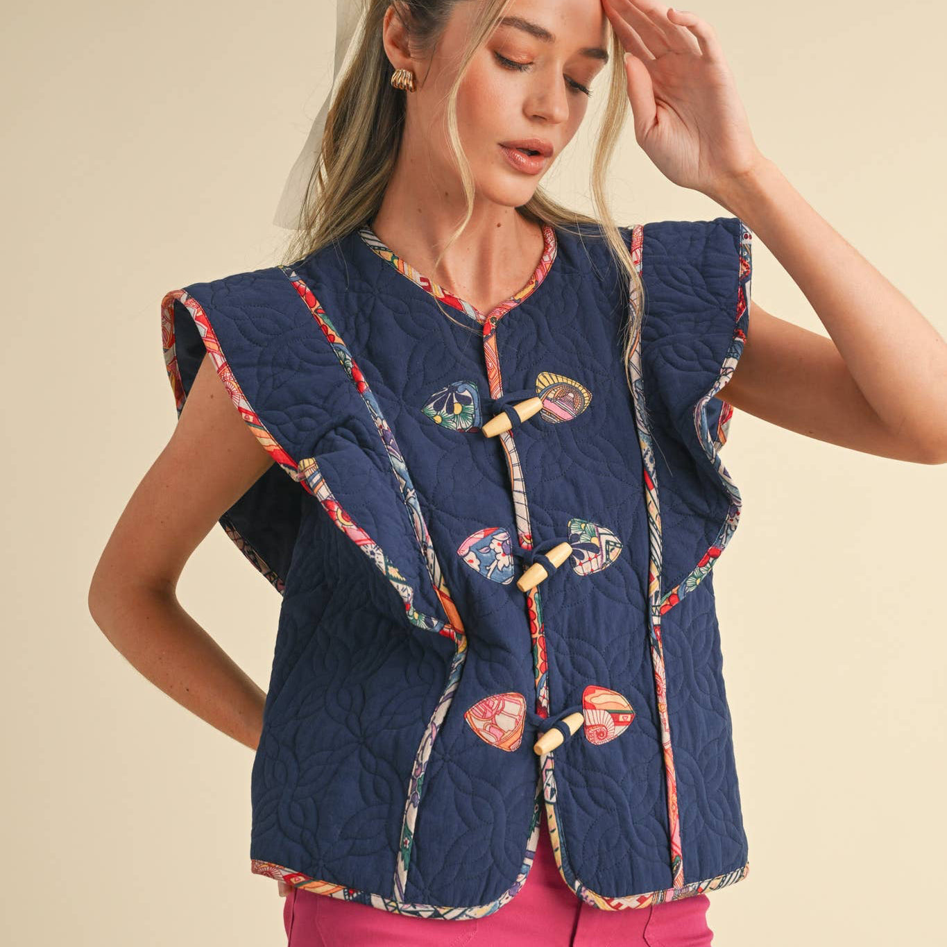 Stand out as a style icon in this quilted print binding vest! Lightweight and sturdy quilted puffer shapes this chic vest that features contrast print binding throughout and has wood toggle closure, ruffled flutter sleeves, and side pockets. Add this versatile statement piece to any outfit for an instant upgraded look!