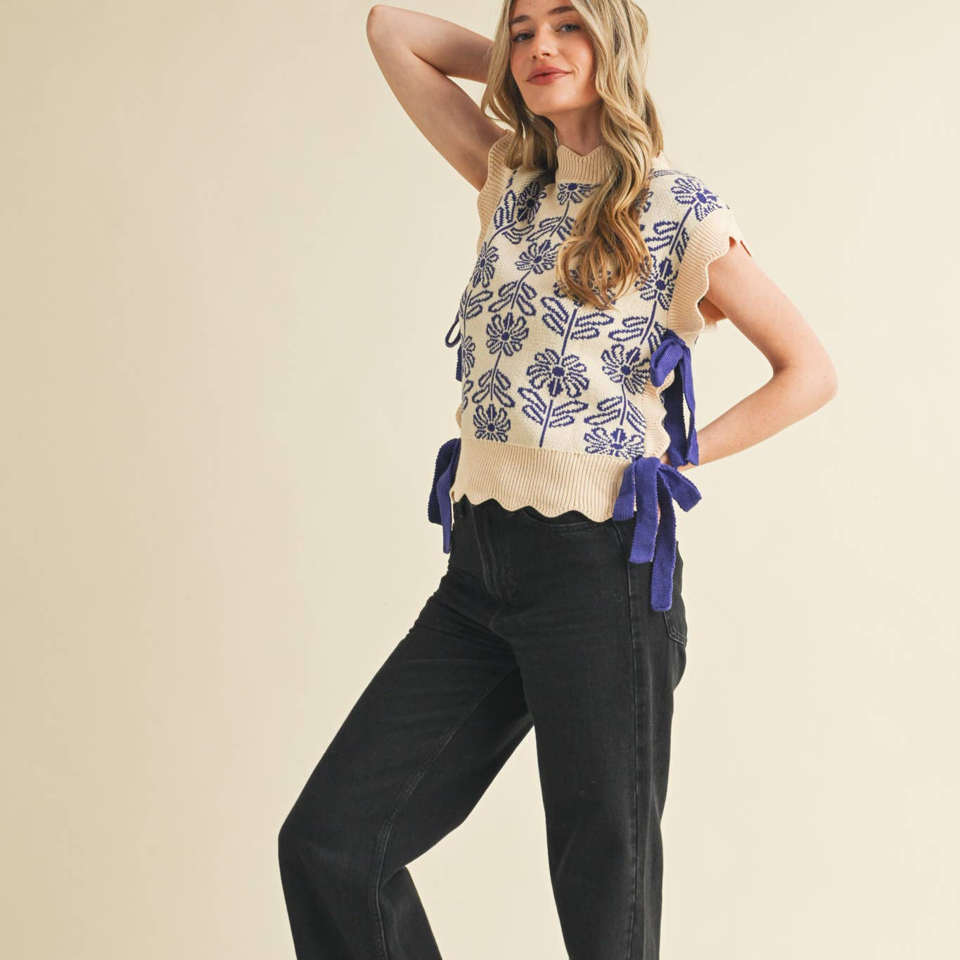 Add an effortless touch to all your fave 'fits with this floral sweater vest! Cozy knit shapes this trendsetting sweater vest that has floral knit design, a scalloped mock neck, and contrast knit ties on the sides. Scalloped edges add a unique accent to this versatile sweater vest!