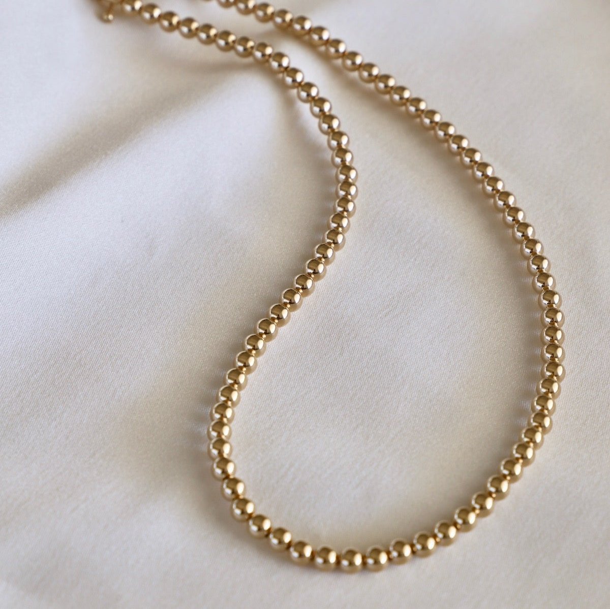 Sprinkle some sparkle into your wardrobe with our Gold Filled 5MM Beaded Necklace. This dazzling piece will add a touch of elegance to any outfit, perfect for both casual and formal occasions. Shine bright like a diamond with this must-have accessory!