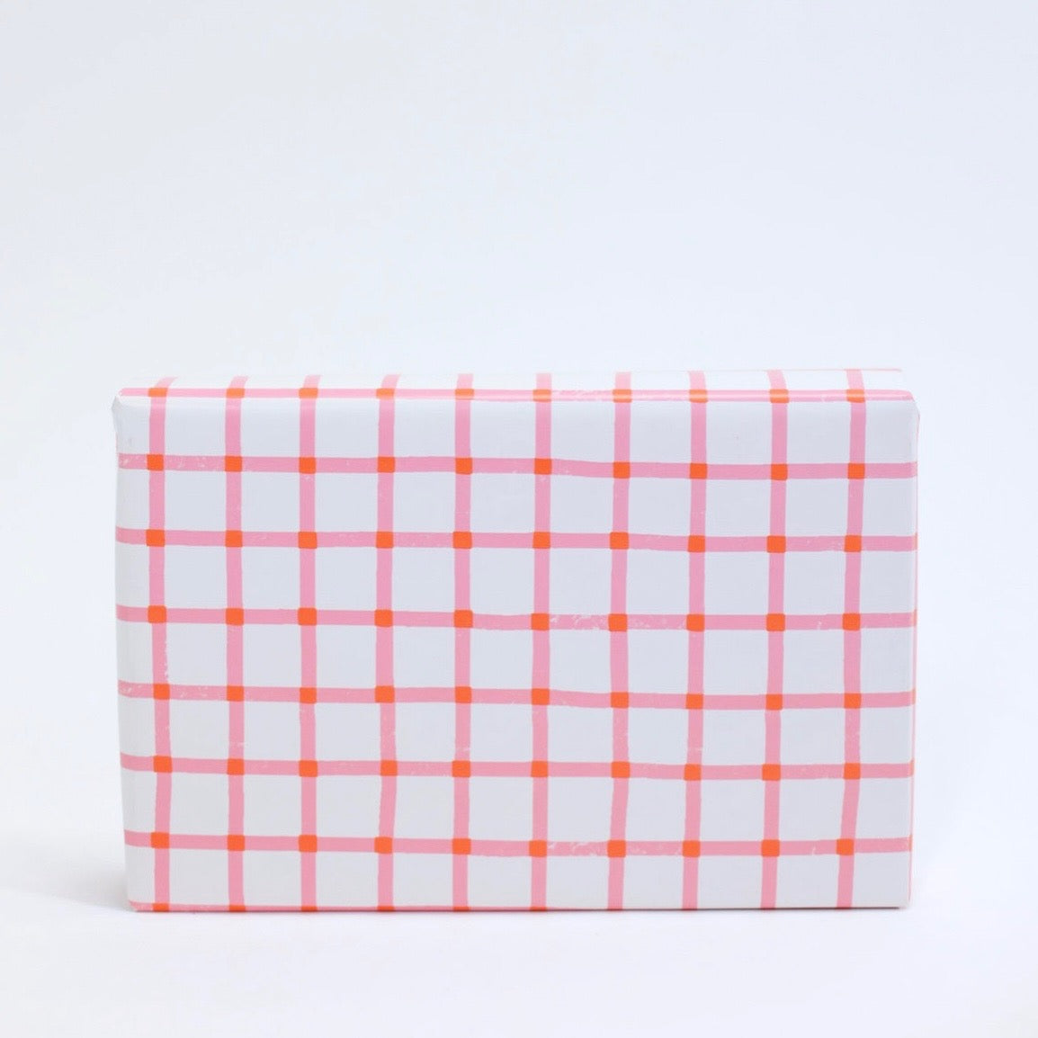 white wrapping paper with a small pink and red grid pattern
