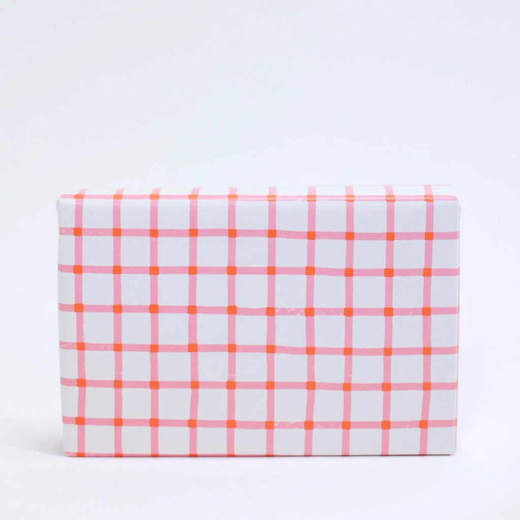 white wrapping paper with a small pink and red grid pattern
