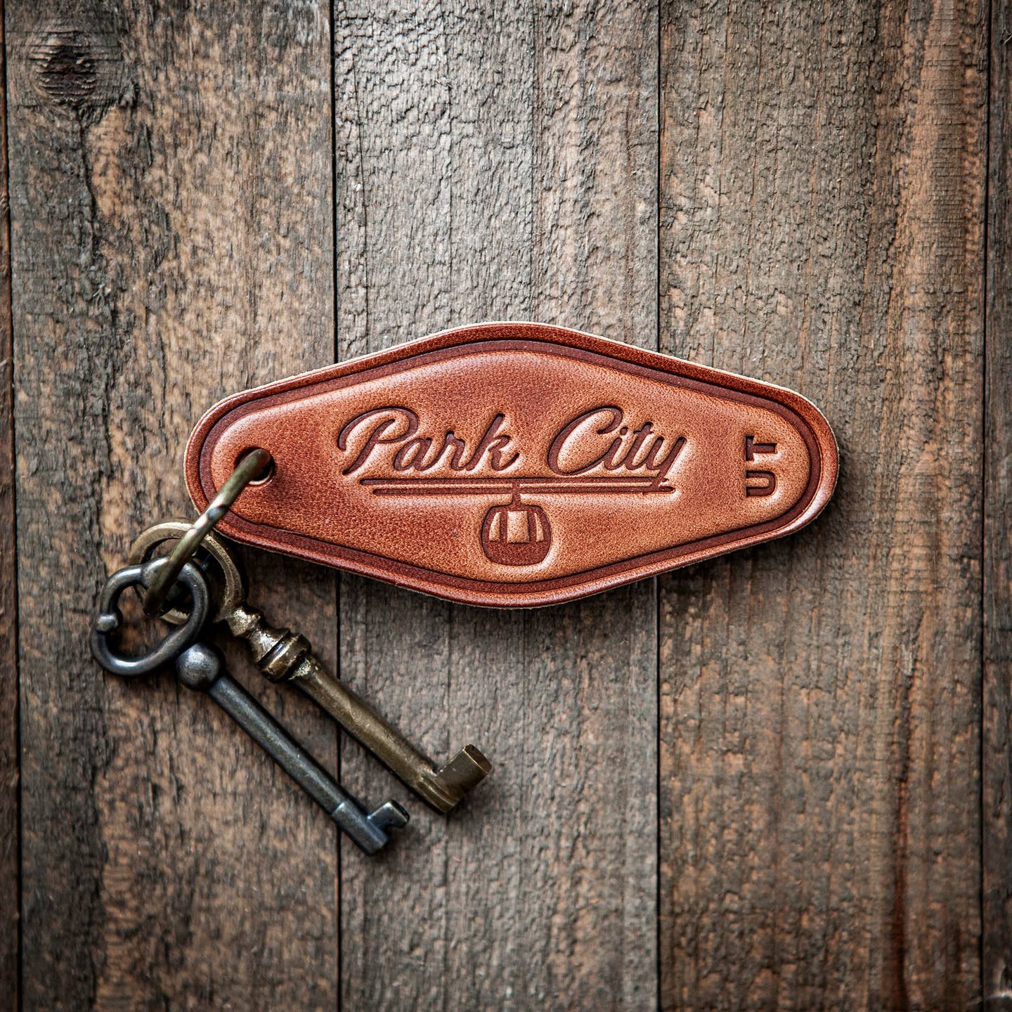 This leather keychain comes in a classic motel style with “Park City” beautifully written in calligraphy on the front. Our leather keychains are cut and pressed by hand from some of the thickest and finest harness leather available, and patina beautifully as they age.

Size: 4”