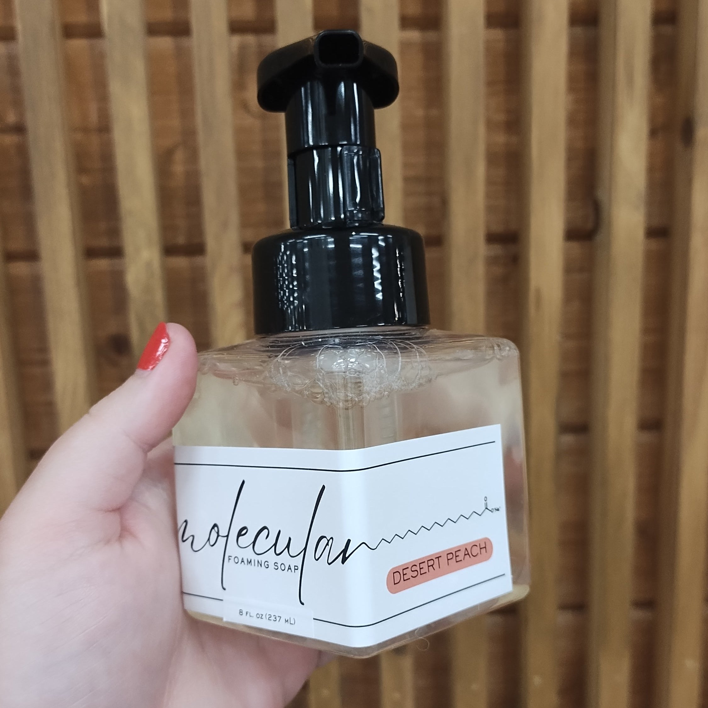 Square plastic bottle with black pump and minimalist white label. 