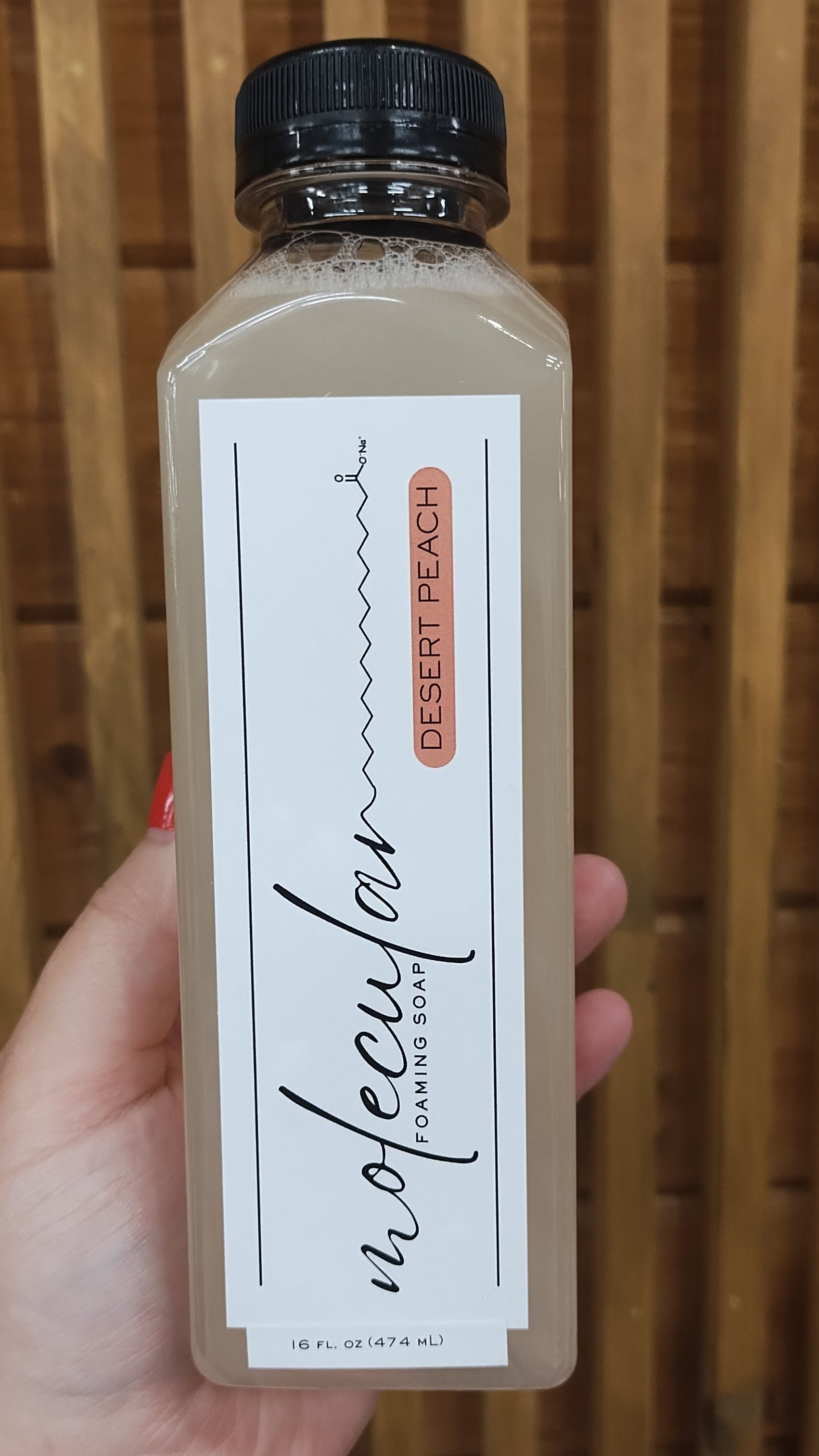 Tall clear rectangle plastic bottle with black lid and white minimalistic label. 