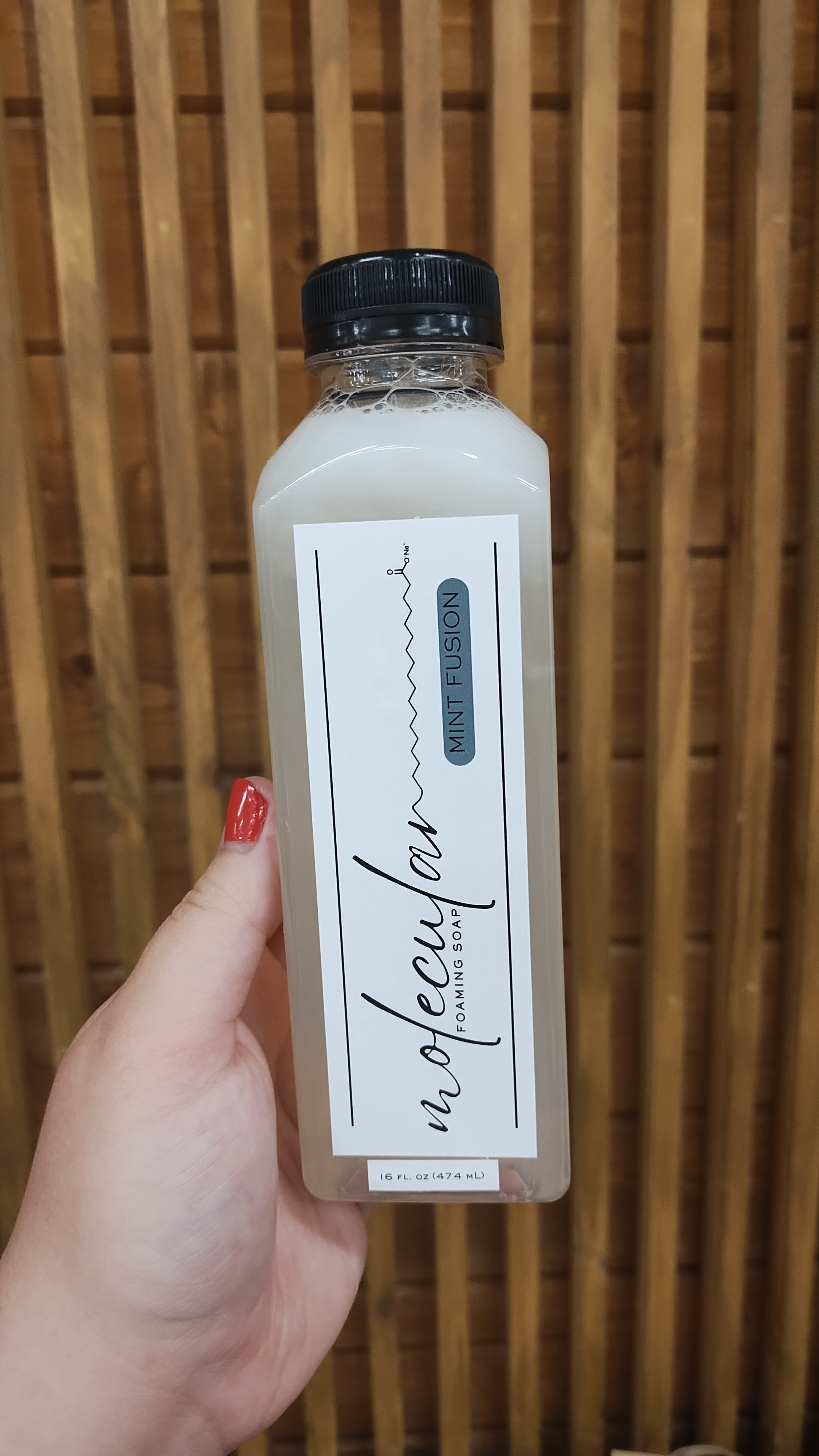Tall rectangle plastic bottle with black lid and white minimalistic label. 