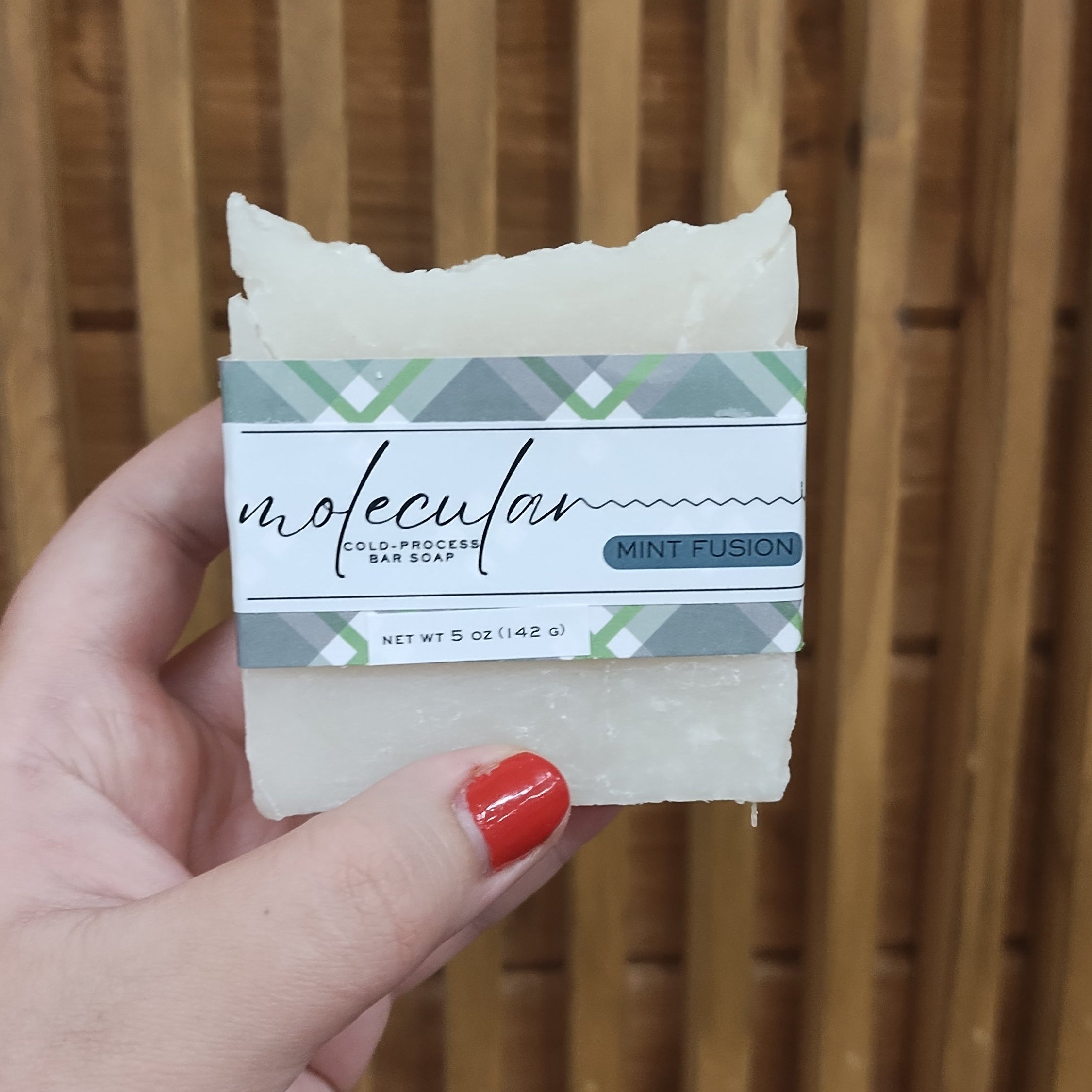 Rough white bar soap with a green plaid label. 