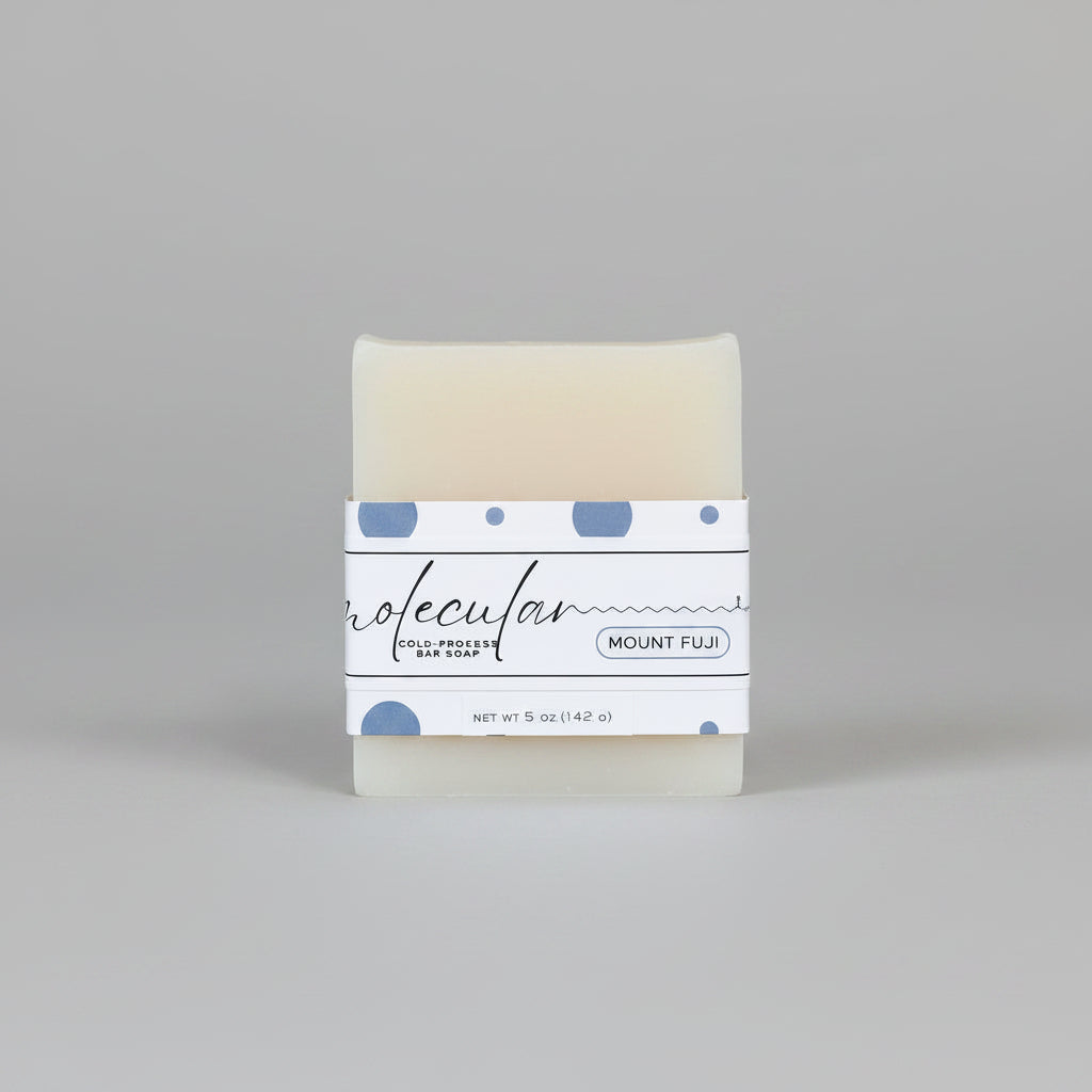 Rough cut white bar soap with a blue dot label. 