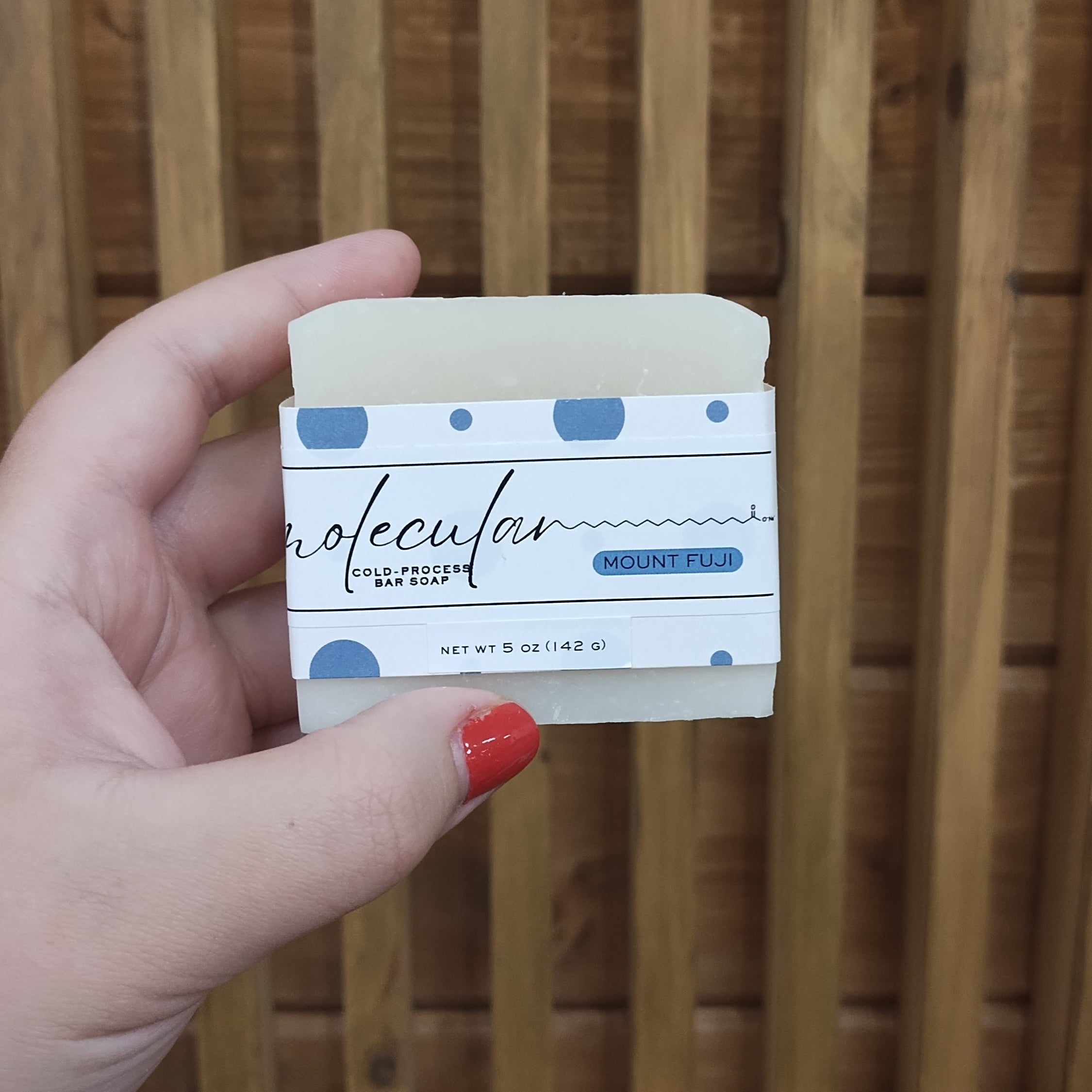 Rough cut white bar soap with a blue dot label. 