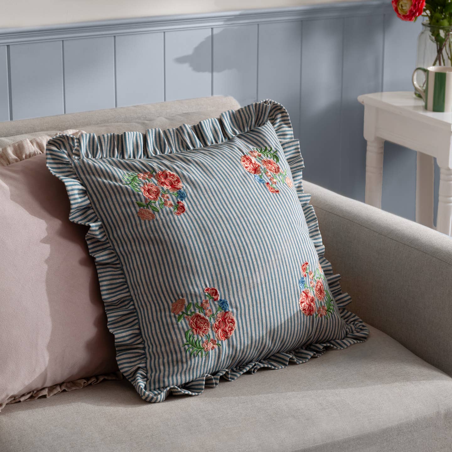 Elevate your living space with the Martha Embroidered Ruffle Cushion, where timeless charm meets thoughtful design. Featuring a linen-look fabric with a natural textured feel, this cushion is adorned with delicate floral embroidery set against subtle striped hues, creating an effortlessly refined country cottage aesthetic. The 5cm ruffle trim adds a touch of softness and elegance, while the relaxed yet exquisite detailing makes it a versatile addition to bedrooms or cosy sitting areas.