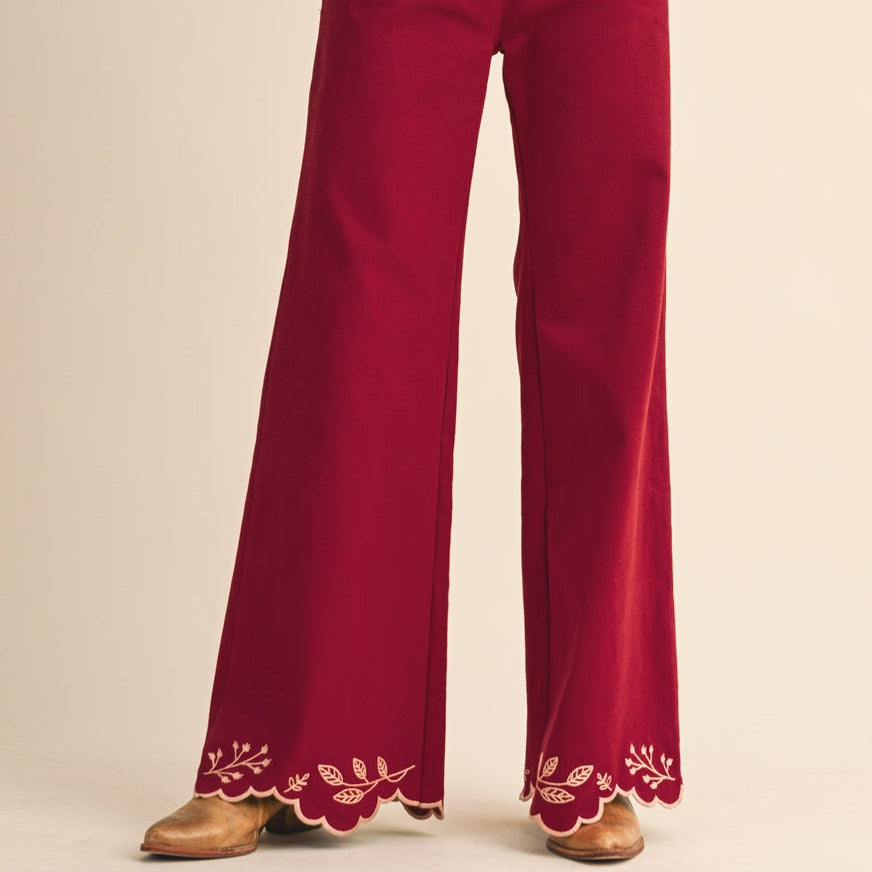 These Cowgirl Embroidery High Rise Flared Pants combine style and comfort with a flattering high-rise fit and flared hem featuring scalloped embroidery. The clay red color adds warmth, while front and back patch pockets provide practical detail. Embroidered cowgirl designs on the back pockets give a unique, charming touch to your everyday look. Perfect for adding a bit of western flair to your wardrobe.