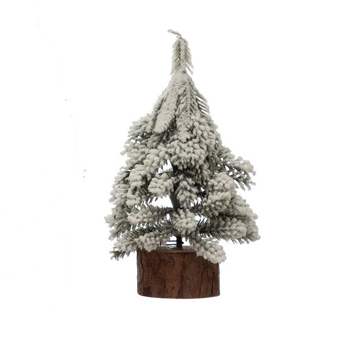 Small decorative Christmas tree with snow effect on a white background