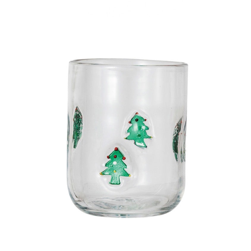 Clear glass tumbler with Christmas tree designs on a white background
