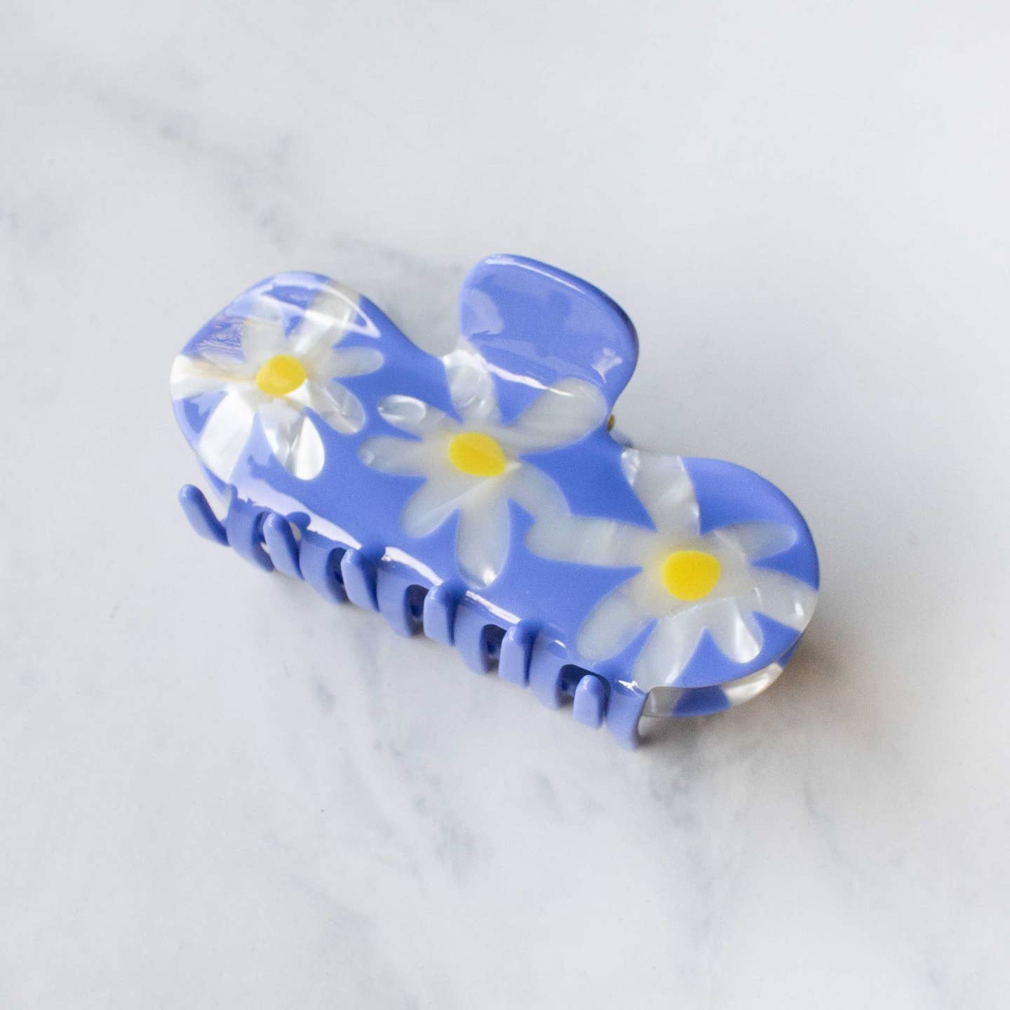 Add a cheerful touch to your hairstyle with this Daisy Curved Hair Claw Clip in vibrant blue. Featuring three detailed daisies and a smooth curved top, it holds your hair gently yet securely throughout the day. Perfect for adding a burst of color while keeping your hair comfortably in place.

Material: Cellulose Acetate