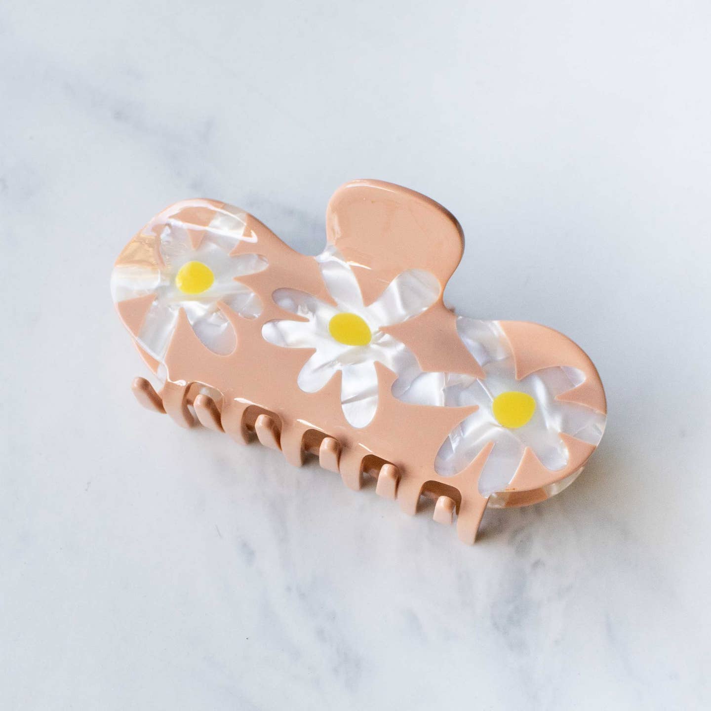 Add a cheerful touch to your hairstyle with this Daisy Curved Hair Claw Clip in soft mocha. Featuring three detailed daisies and a smooth curved top, it holds your hair gently yet securely throughout the day. Perfect for adding a burst of color while keeping your hair comfortably in place.

Material: Cellulose Acetate