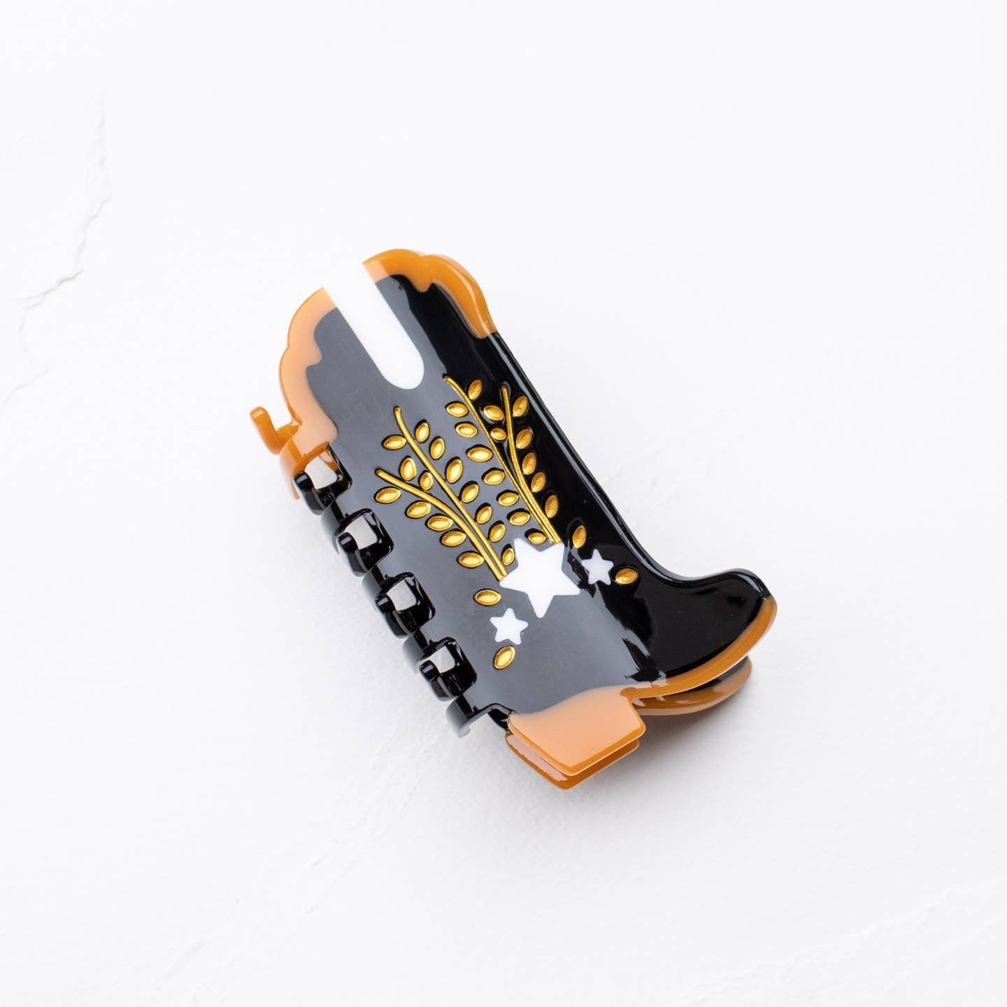 Shooting Star Cowboy Boot Hair Claw Clip, the perfect accessory for any Western-inspired outfit. Made with sustainable materials, this clip showcases an intricate boot design and features a secure, easy-to-use grip. Upgrade your hair game with this eco-friendly and stylish clip.