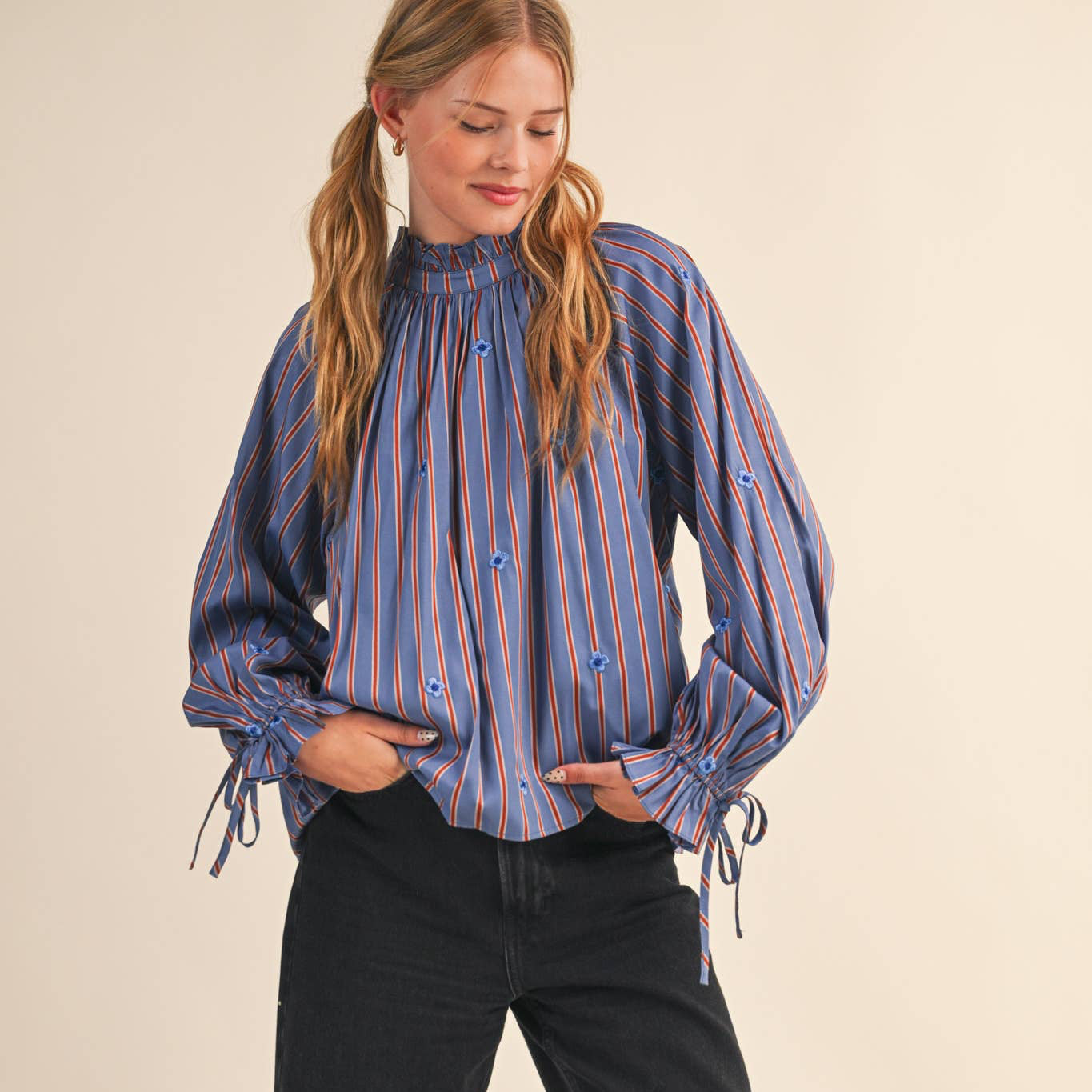 This women's long sleeve blouse features elegant blue and red colored pinstripes and delicate tiny embroidered flowers, adding a subtle touch of charm. The ruffle neck detail enhances its feminine appeal, making it a versatile piece for both work and casual outings. Comfortable and stylish, it’s designed to support your confidence and grace throughout the day.