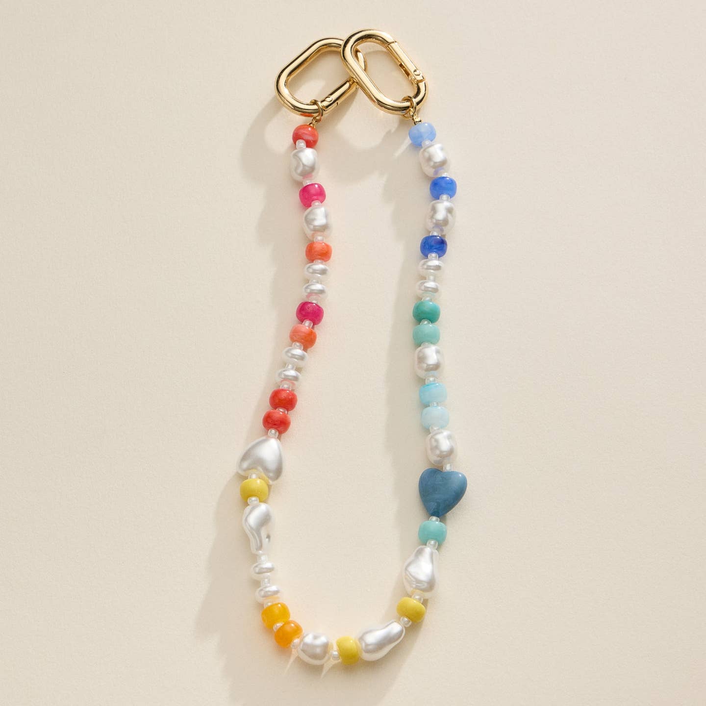 Add a unique touch to your bag with this colorful beaded charm featuring heart and pearl accents and a gold clasp. A fun and stylish accessory perfect for customizing handbags or keys.