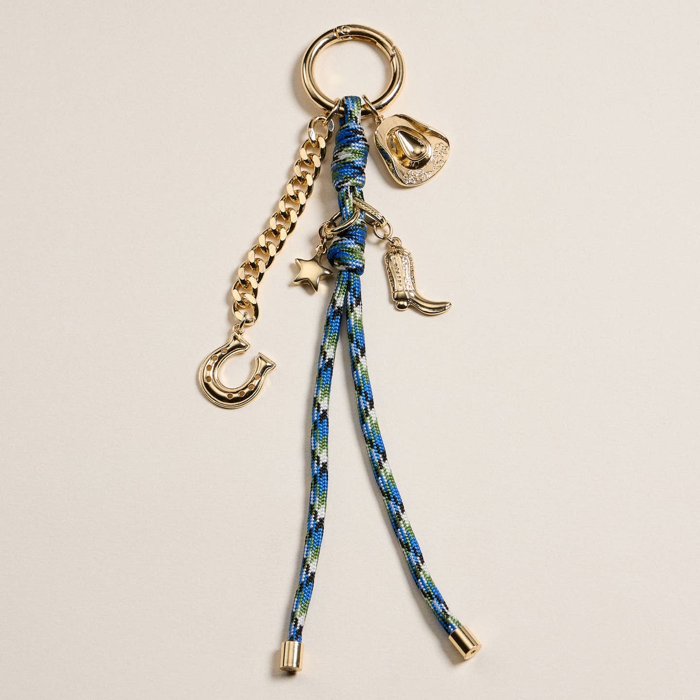 Add a touch of western flair to your accessories with this 7.5 inch Western Charm Keychain. Crafted from durable enamel with gold-tone accents, it features playful charms including a cowboy hat, boot, horseshoe, and star. The multicolor braided rope adds a rustic vibe while the gold chain enhances its modern style. Perfect for keys, bags, or as a unique gift.

Details:

Materials:Enamel and gold-tone alloy
Charms:Cowboy hat, boot, horseshoe, star
Length: 7.5 inches
Use: Keychain, bag charm, purse accessory