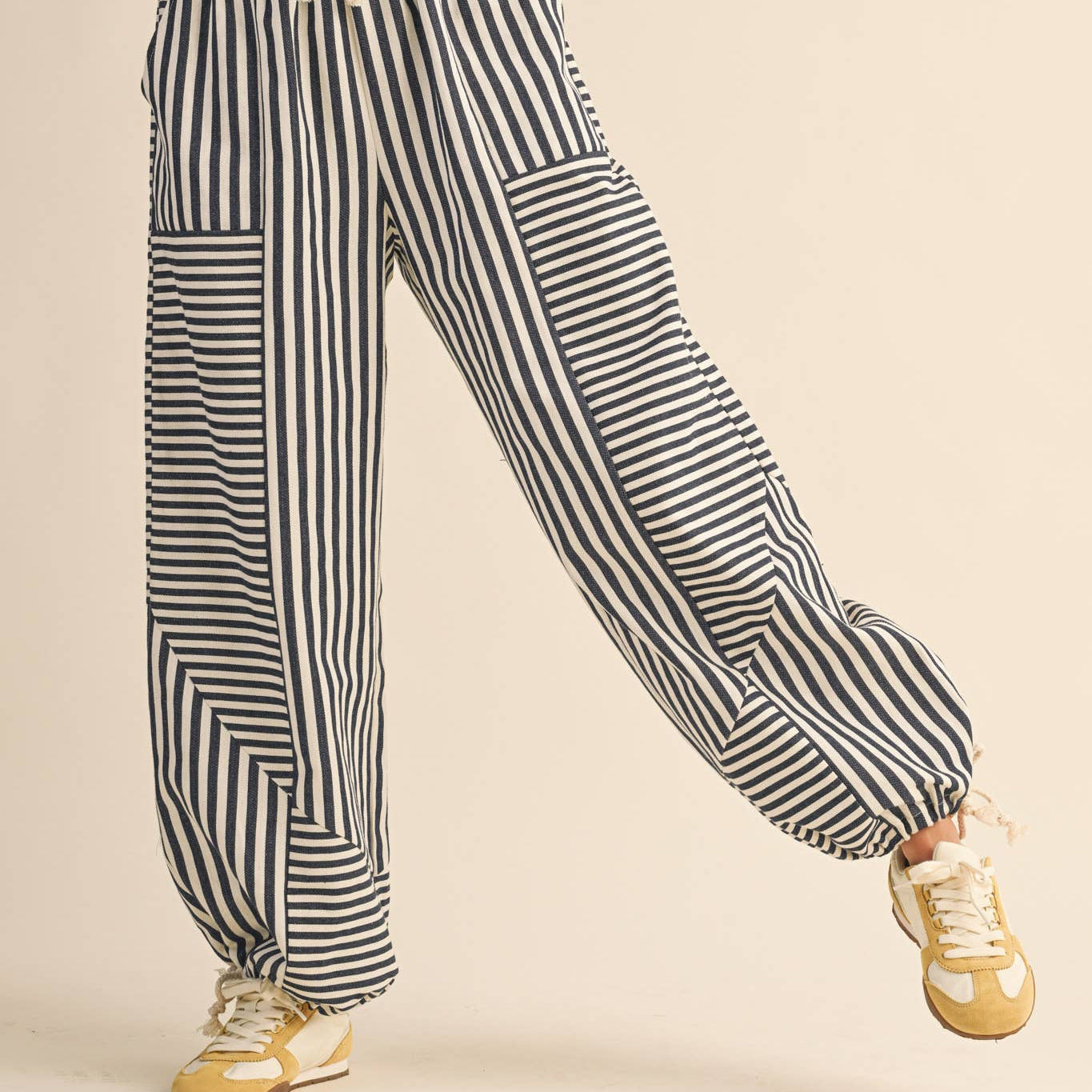 Experience casual comfort with these Mixed Dark Blue Stripes Parachute Pants. Made from 100% cotton, they offer breathability and softness for all-day wear. The dark navy blue striped design adds subtle style, while the relaxed parachute fit ensures freedom of movement. Ideal for laid-back days or effortless streetwear looks.