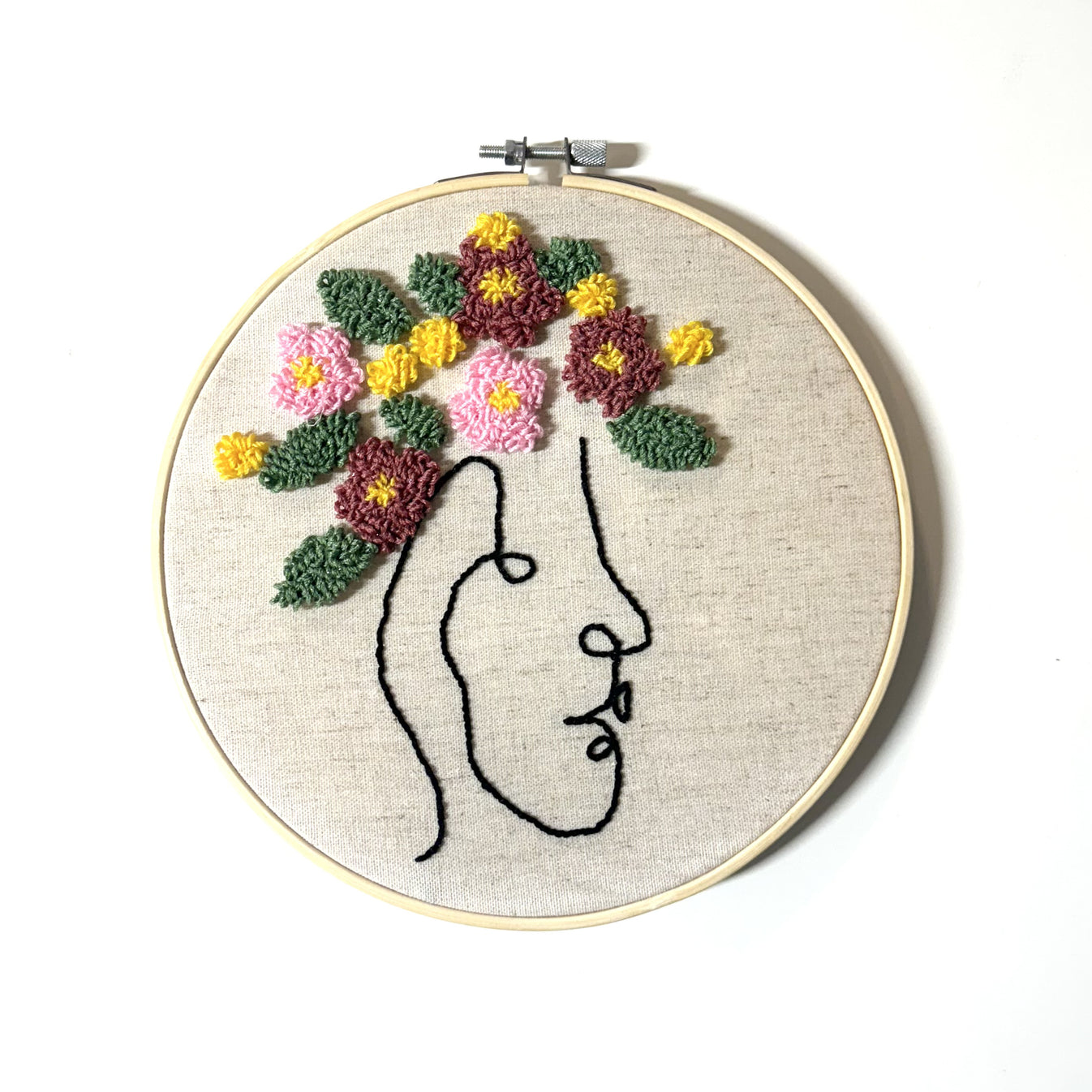 black face silhouette and pink, yellow, and purple flower crown embroidery floss punch