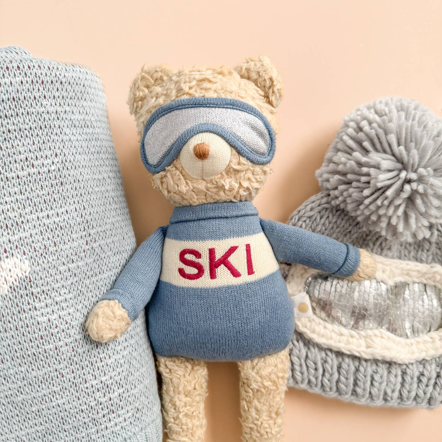 Benjamin Bear is a bit of a powder hound. He hits the slopes early for the fluffiest snow and to avoid crowds. Benjamin makes sure to take a cocoa break at precisely 10 o'clock. Gift together with the matching blanket, Ski sweater, or Ski Goggles Beanie.

Details:

14" tall
100% Organic Cotton, exclusive of trim
Recycled Polyester Fill
Designed in Salt Lake City
Care Instructions:

Hand wash cold. Do not bleach. Do not wring. Dry flat in shade. Do not tumble dry. Warm iron.