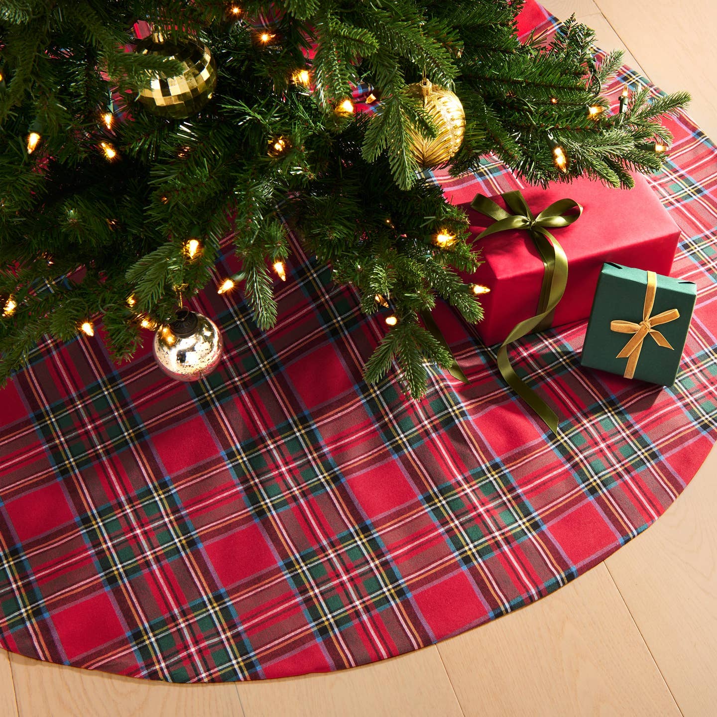 Add a touch of timeless charm to your Christmas tree with our Stowe Tartan Plaid Tree Skirt. Designed to complement a variety of holiday decor styles, this classic tree skirt features a yarn-dyed plaid pattern in two rich color palettes, showcasing shades of Christmas red, hunter green, royal blue, gold, and white. Crafted from a blend of 70% cotton and 30% recycled polyester, this product offers natural softness and a sustainable, eco-friendly option for your holiday decor.