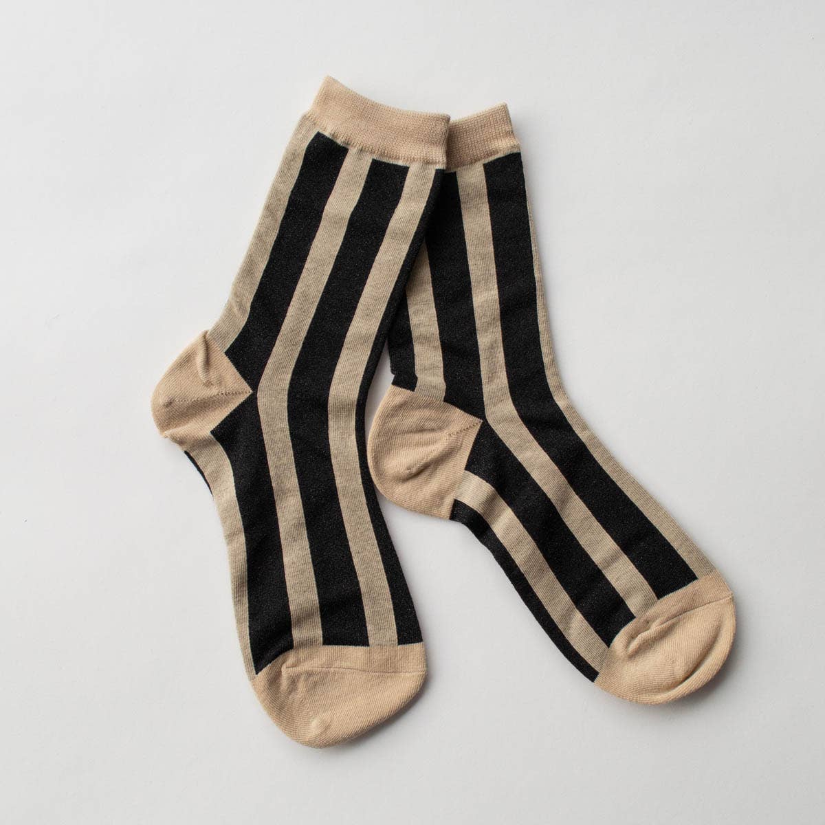 Make a statement with these striking crew socks showcasing bold vertical stripes in black and taupe, enhanced with eye-catching glitter accents. Designed to bring sparkle to your everyday wardrobe, these socks combine playful style with dependable comfort. The crew-length cut provides excellent support and coverage for all-day wear, whether you're heading to the office, out on adventures, or simply relaxing at home. Slip them on and let your feet do the talking with this fun, versatile essential.