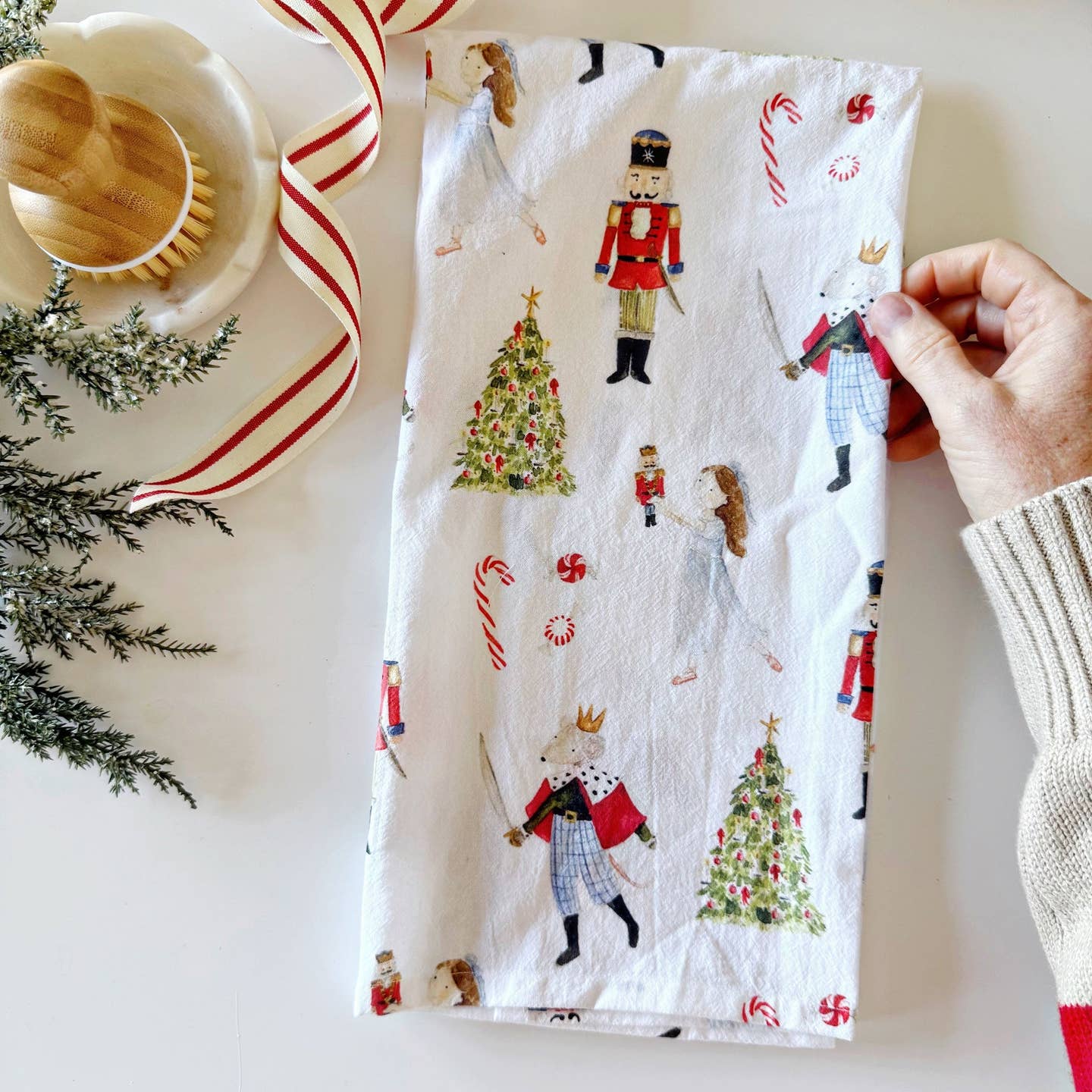 Add a touch of Christmas cheer to your kitchen with this 100% cotton tea towel. Festive Nutcracker illustrations cover the towel making it perfect for gifting, washing up, wrapping up treats, or displaying in your kitchen for a splash of color.

Details

100% cotton flour sack tea towel
19" x 28"
Loop for hanging
Machine wash and dry
Original watercolor artwork by Emily Lex