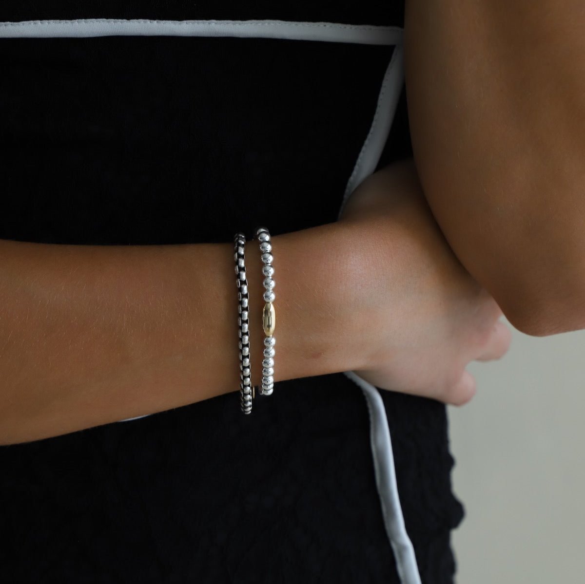 Introducing the Nova Chain Bracelet - a stunning, two tone accessory featuring a round silver box chain with a gold lobster clasp and end chain with a coin drop. The perfect blend of elegance and edge, this bracelet will elevate any outfit with its sleek, modern design.