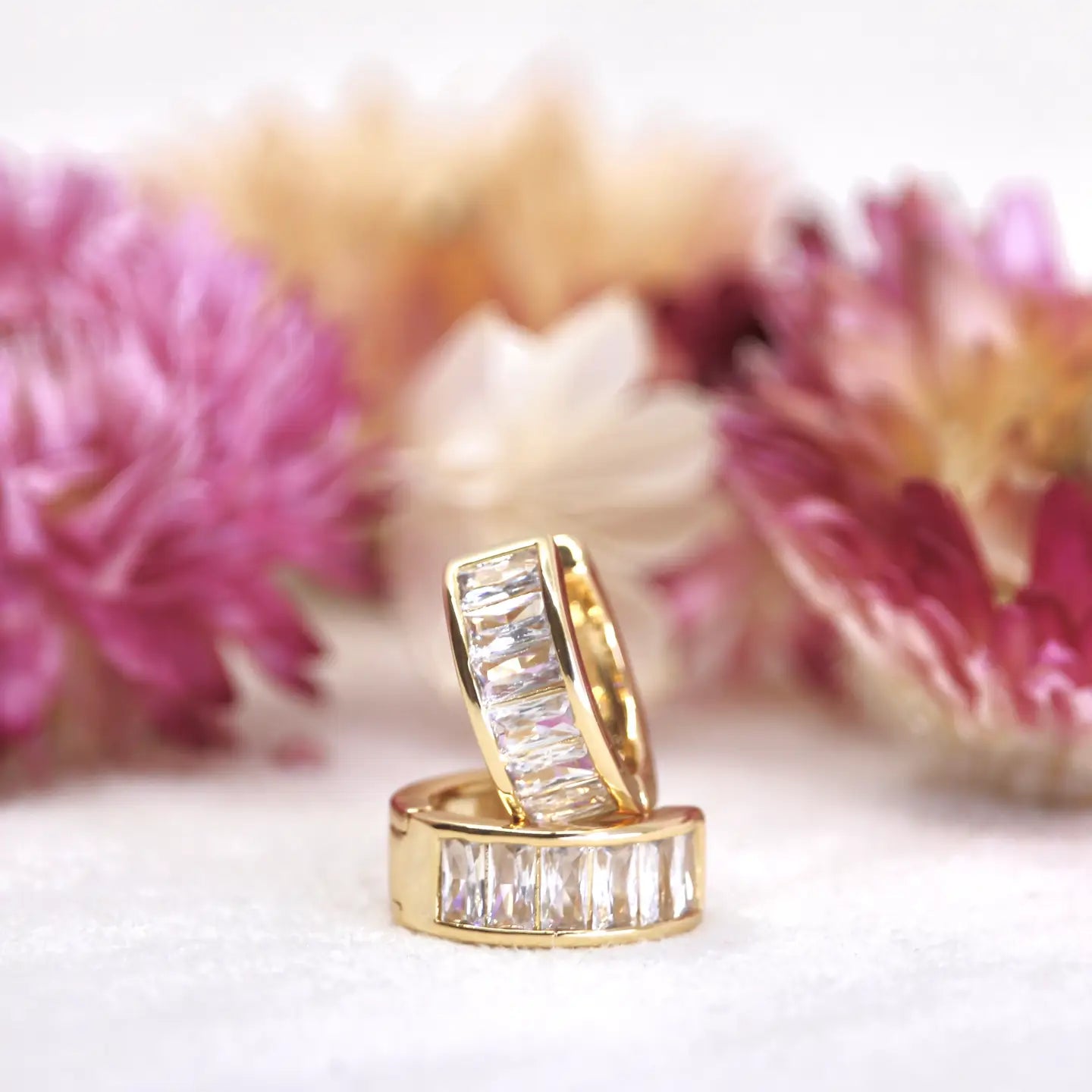 These hoops are named after the galaxy with a rectangular shape. It has a bright shimmering appearance due to the rapid formation of young stars within its center. Shine on with these unique and stunning Leda hoops

Details:
925 sterling silver with gold plating
extra layer of tarnish resistance
baguette clear cubic zirconia stones
hinge hoop closure