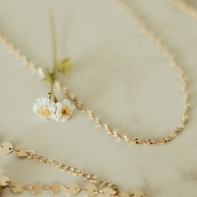 The Amelia Gold Filled Twist Necklace is the perfect piece to stack with other&nbsp;necklaces or wear as a stand alone accessory. She’s 18k gold filled, tarnish and wear resistant, and made to last. Hypoallergenic and nickel free, this unique and dainty 3mm chain is the perfect accessory all year long.&nbsp;16" length.