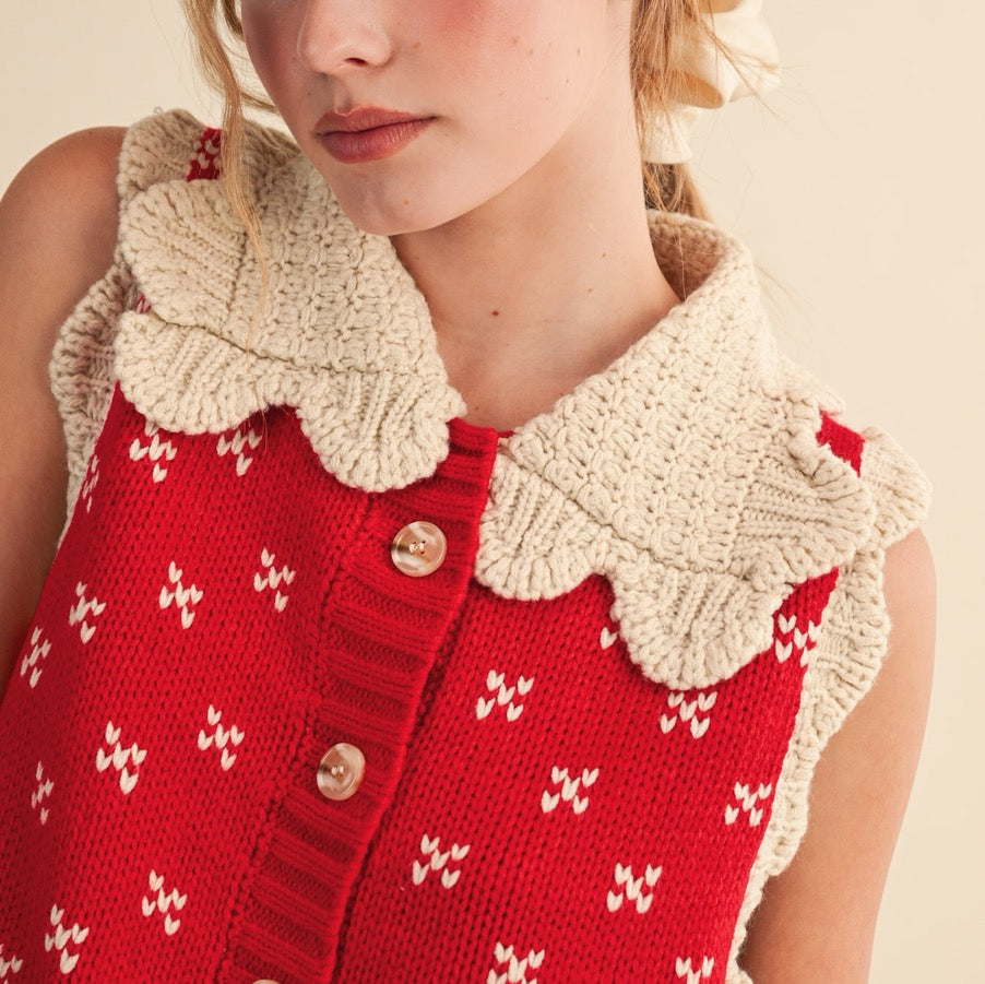 Elevate your layering game with this charming red sweater vest, designed to bring a touch of vintage-inspired style to your everyday wardrobe. The distinctive doll collar in soft oat tones creates a sweet contrast against the rich red knit, while ribbed detailing adds texture and structure. Perfect for pairing over long-sleeve tees or delicate blouses, this versatile piece works beautifully for casual outings or dressed-up occasions. The quality knit construction ensures lasting comfort and durability.