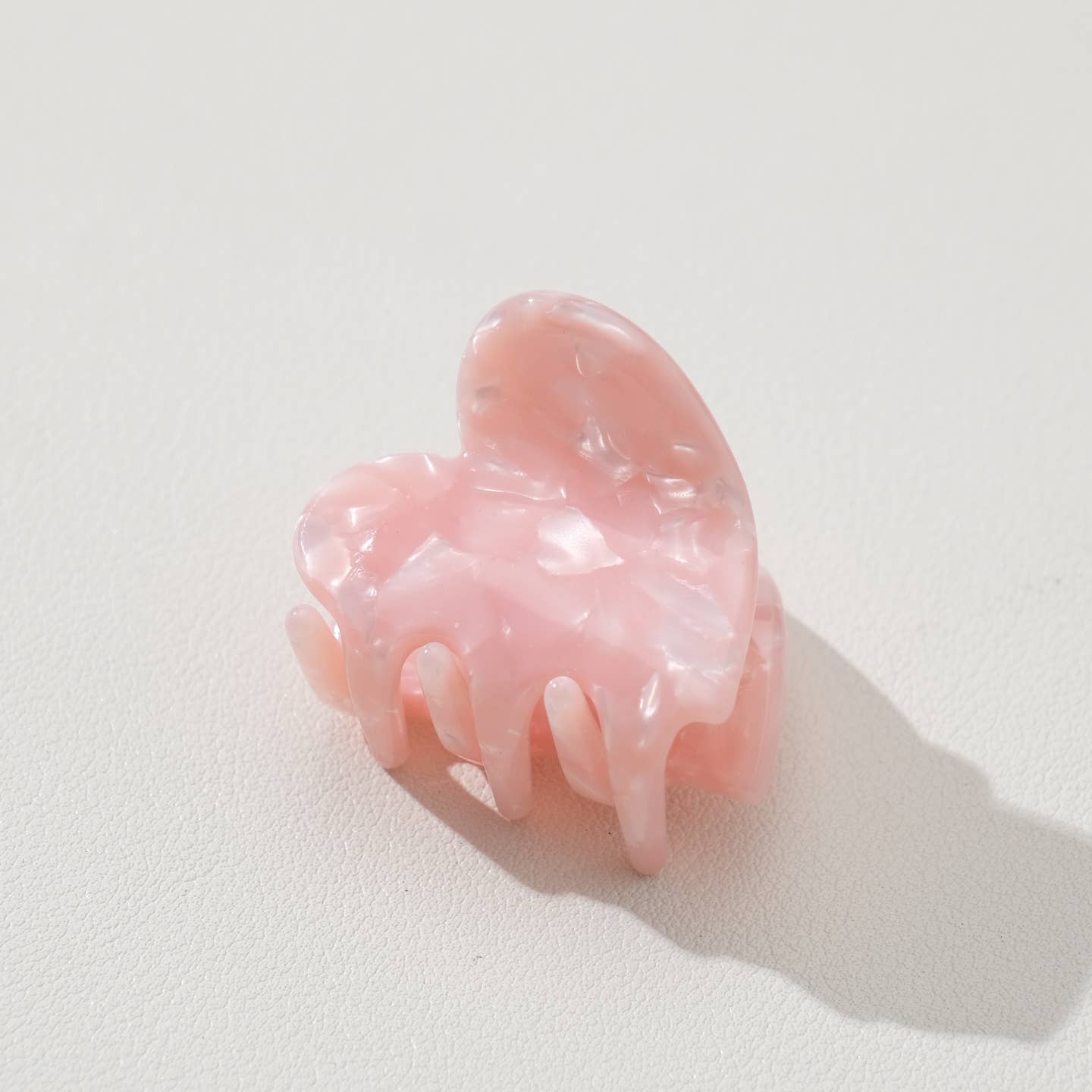 Adorable and functional, this mini heart claw clip brings a soft pop of saltwater pink charm to any hairstyle. Perfect for securing small sections of hair or adding a sweet accent to your look, this petite clip combines playful design with reliable hold. Whether you're styling for everyday wear or special occasions, this heart-shaped accessory is a delightful way to express your personal style while keeping hair in place.

Details:

Small (1.7 inch)
Materials: Cellulose Acetate