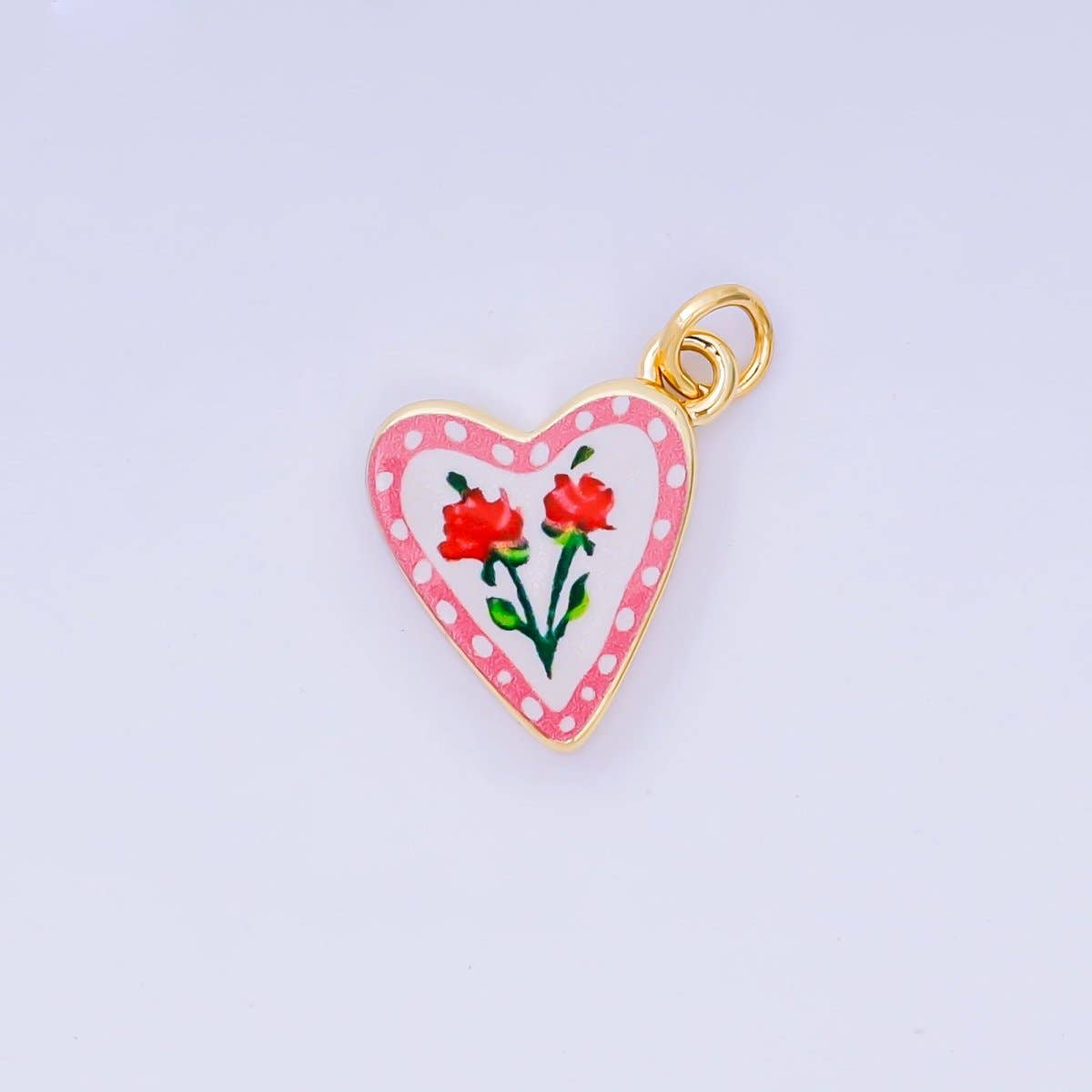 A delicate heart-shaped charm adorned with two roses in soft, romantic detail. Crafted from brass with 24K gold-filled plating and vibrant enamel work, this piece combines elegance with durability. Perfect for charm bracelets, necklaces, or jewelry customization projects. Lead-free and nickel-free for safe, comfortable wear.