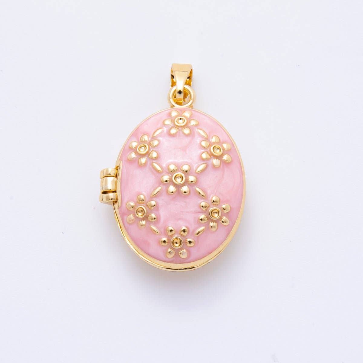 Tiny treasure chest for your heart! This 18K gold filled locket features delicate floral engravings over a soft pink and swings open to hold your most precious memories—a photo, a note, or whatever makes you smile. Crafted in gold-filled brass and completely lead and nickel-free, it's the perfect companion for everyday wear or a meaningful gift. At just 24mm, it's small enough to tuck close but mighty enough to spark joy.
