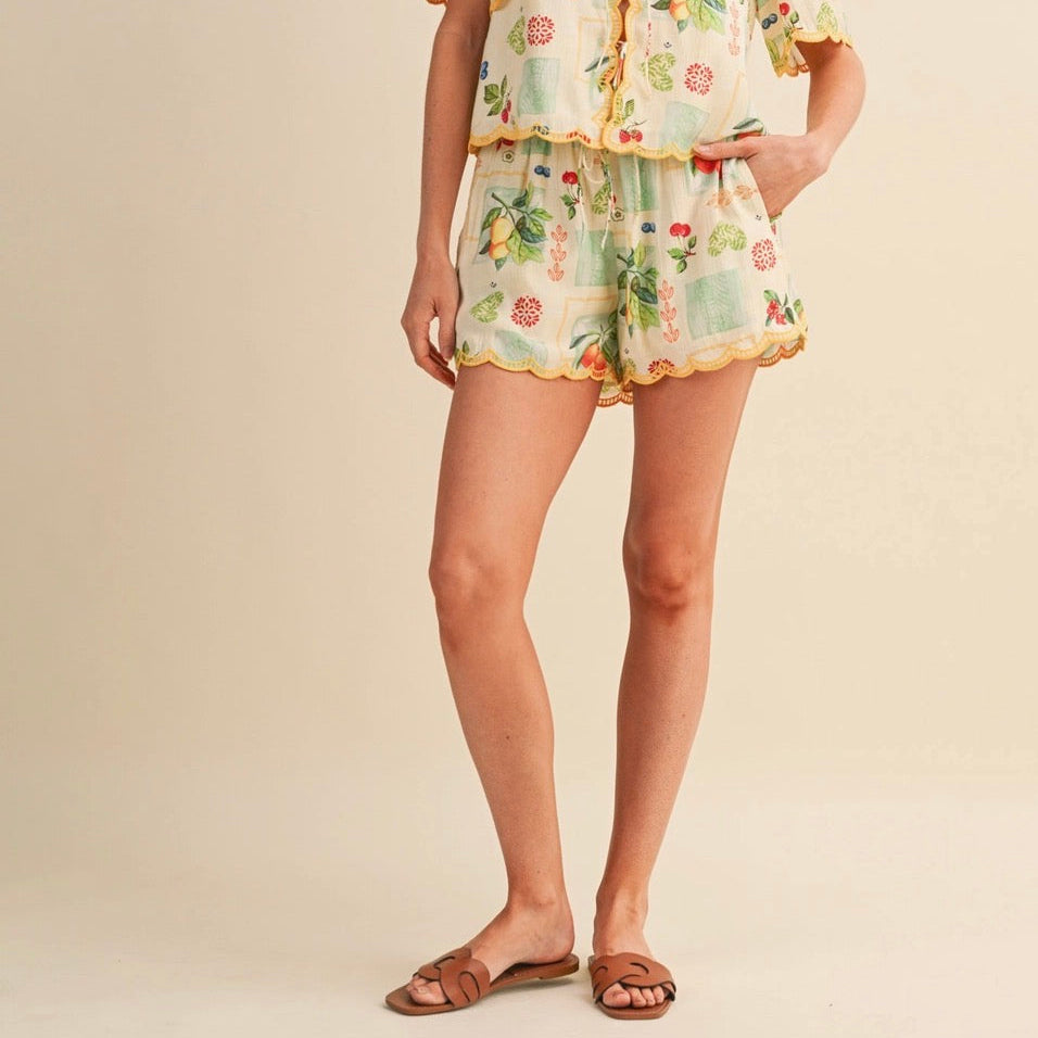 Celebrate your style with these charming Fruit Print Embroidered Scallop Shorts. The delicate embroidered scalloped hem adds a playful, feminine touch, while the high elastic waistband with tying detail ensures a comfortable, customizable fit. Practical pockets and a lined interior make these shorts as functional as they are fun. Crafted from 100% polyester, they're easy to care for and perfect for warm-weather adventures. Whether you're heading to brunch or a casual day out, these shorts are perfect.