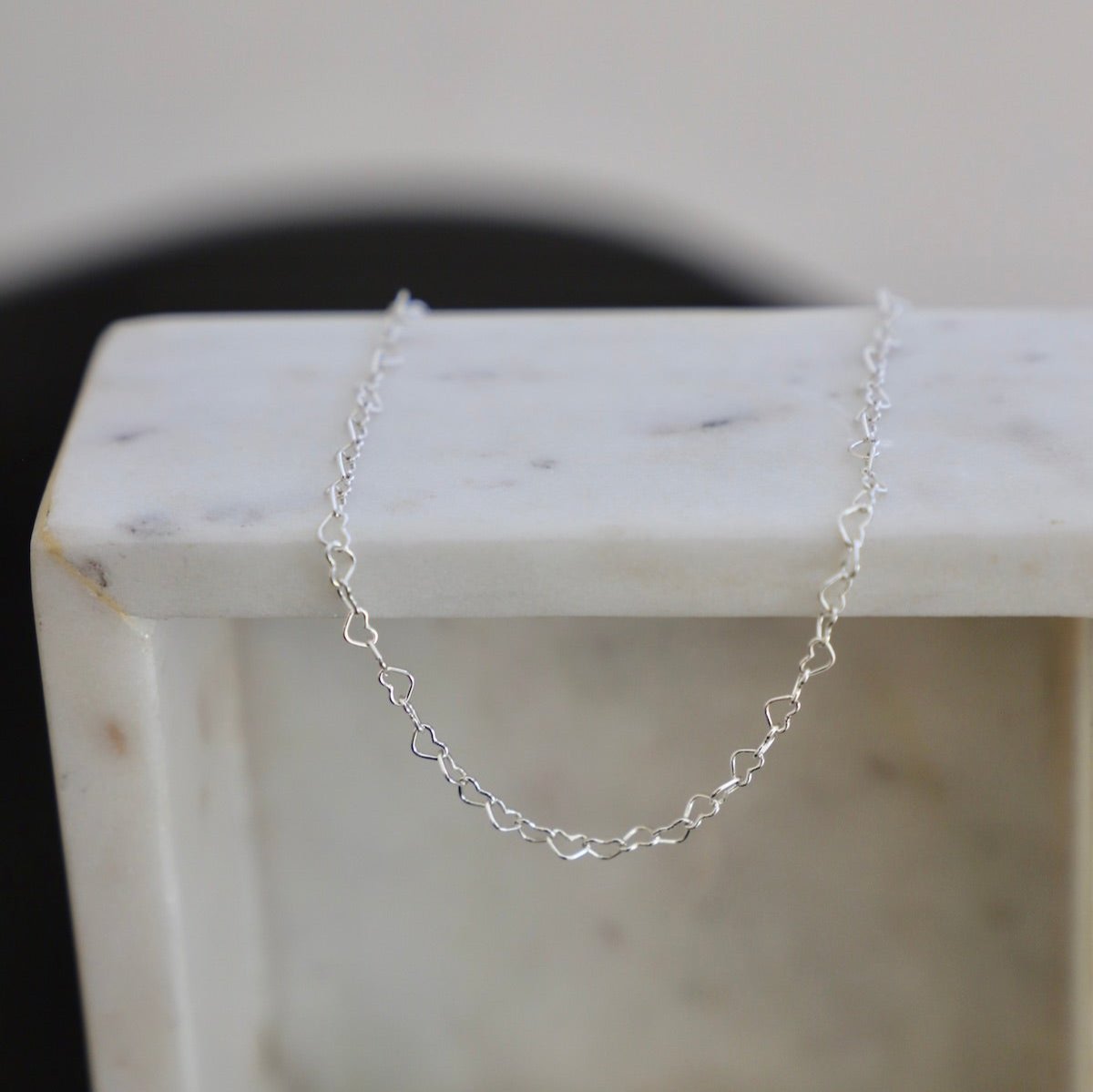 This elegant chain necklace features interconnected hearts, symbolizing everlasting love and affection. The delicate design adds a touch of romance to any outfit, making it the perfect accessory for any occasion. Crafted with high-quality materials, this necklace is a timeless addition to your collection. Silver