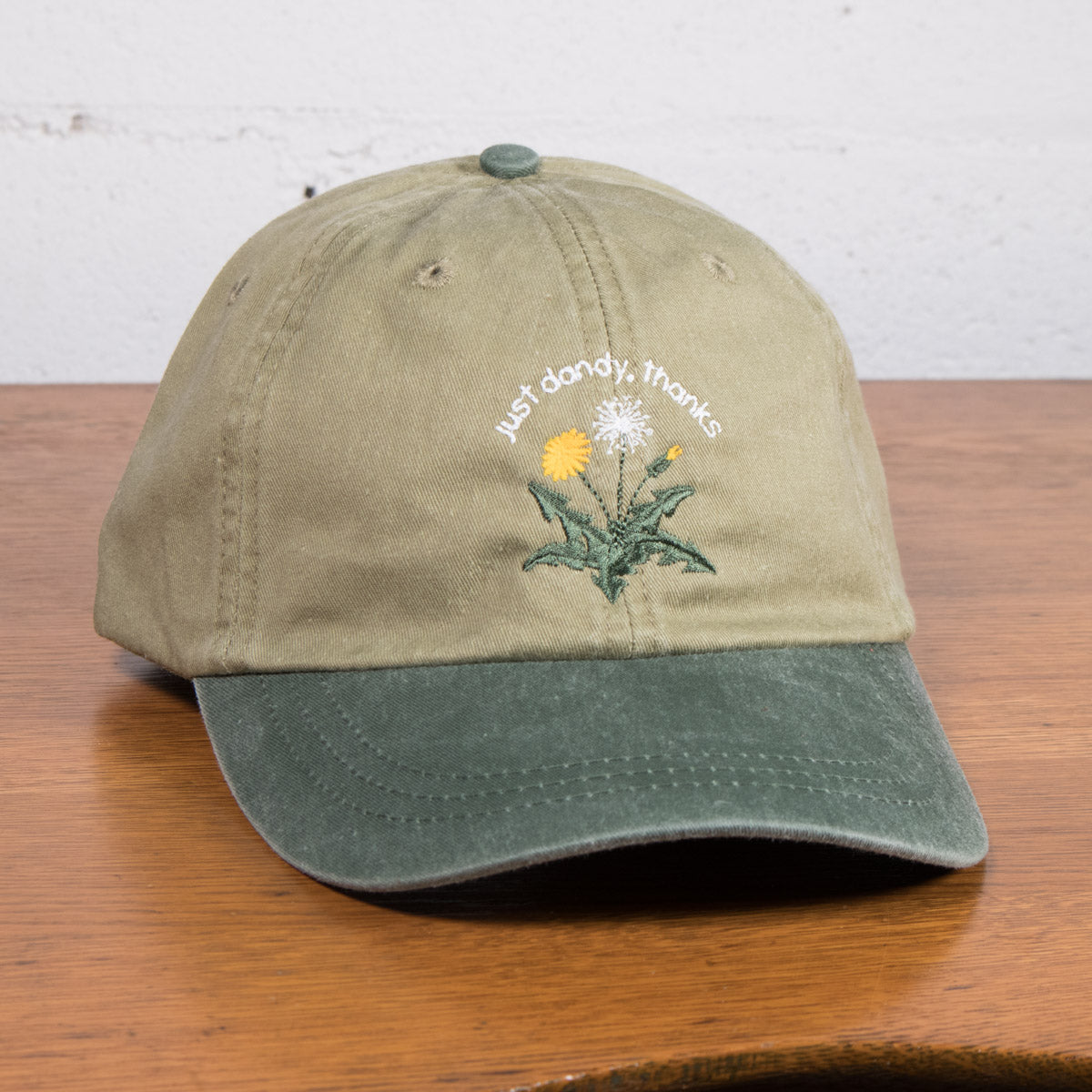 The "Just Dandy, Thanks" Hat is about existing even when others might see you as an outsider. Dandelions are much more than just a weed, so whether you’re a “black sheep” or simply “not like the others,” this cap says: "I’m thriving and I'm doing just dandy, thanks!"

Made for sunny strolls, casual hangs, and moments worth smiling about.

Details:

Playful Embroidery of a dandelion thriving
100% cotton dad cap with a breathable mesh lining
Adjustable leather strap, one size fits most