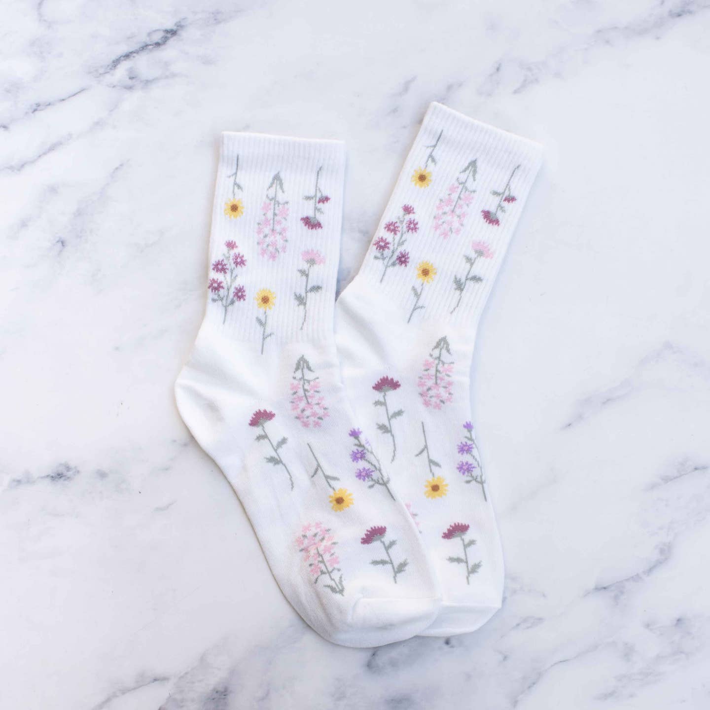 Add a touch of whimsy to your outfit with these playful sage floral socks! Featuring a charming botanical pattern, these socks are made to make a statement. Get ready to turn heads and show off your fun side with these quirky socks.