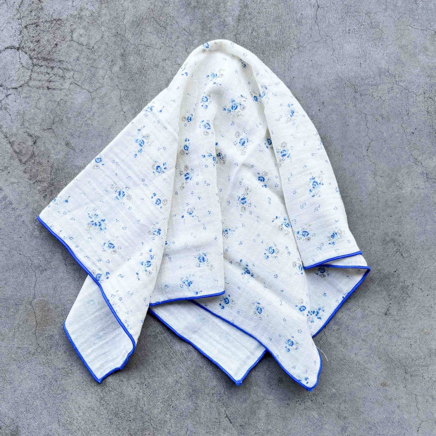 Wrap yourself in timeless charm with this lightweight vintage floral cotton scarf. Featuring delicate scattered blooms on a soft cream background and finished with a colorful contrast stitched edge, this versatile accessory adds a sweet, effortless touch to any outfit. Wear it as a neck scarf, hair scarf, bag accent, or pocket square for everyday vintage-inspired style.