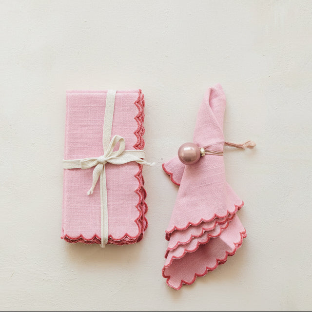 Scalloped Cotton Napkin Set - Red. Bring charm and cozy elegance to your dining table with our Scalloped Cotton Napkin Set in vibrant red. Crafted from soft cotton with beautifully detailed contrasting stitched edges, this set of four adds a thoughtful, inviting touch to every meal and holiday gathering.