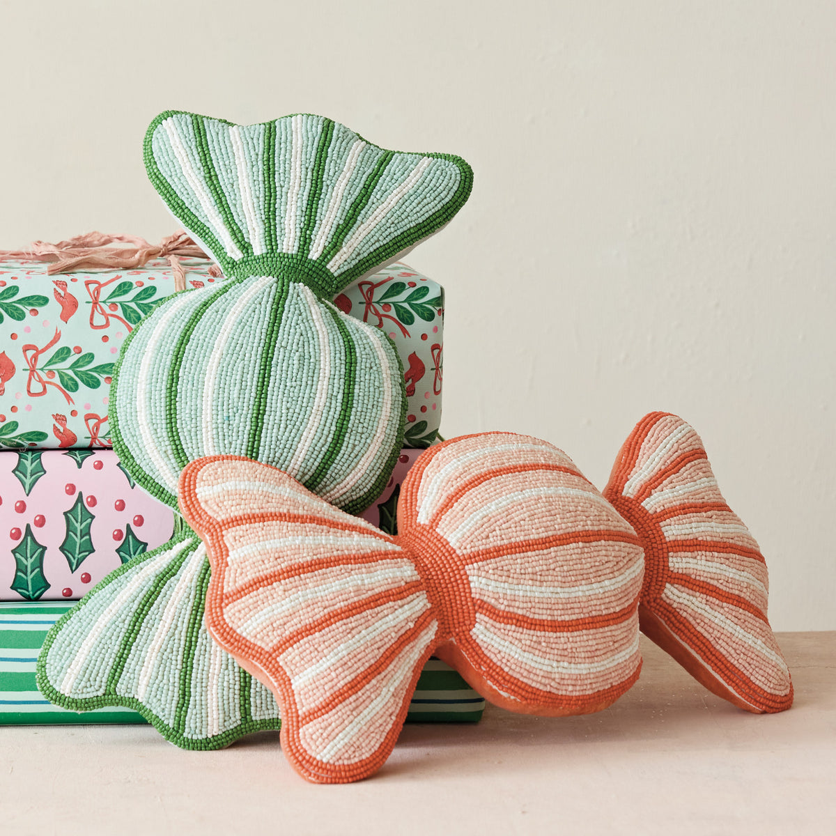 Soft Holiday Whimsy Beaded Candy Pillow - 2 Colors. Bring a touch of sweet, festive charm to your home with our Soft Holiday Whimsy Candy Pillow. Beautifully detailed with shimmering glass beads on the front and a plush cotton velvet backing, this sweet candy-shaped accent piece adds warmth, comfort, and a joyful sparkle to any cozy corner this season.