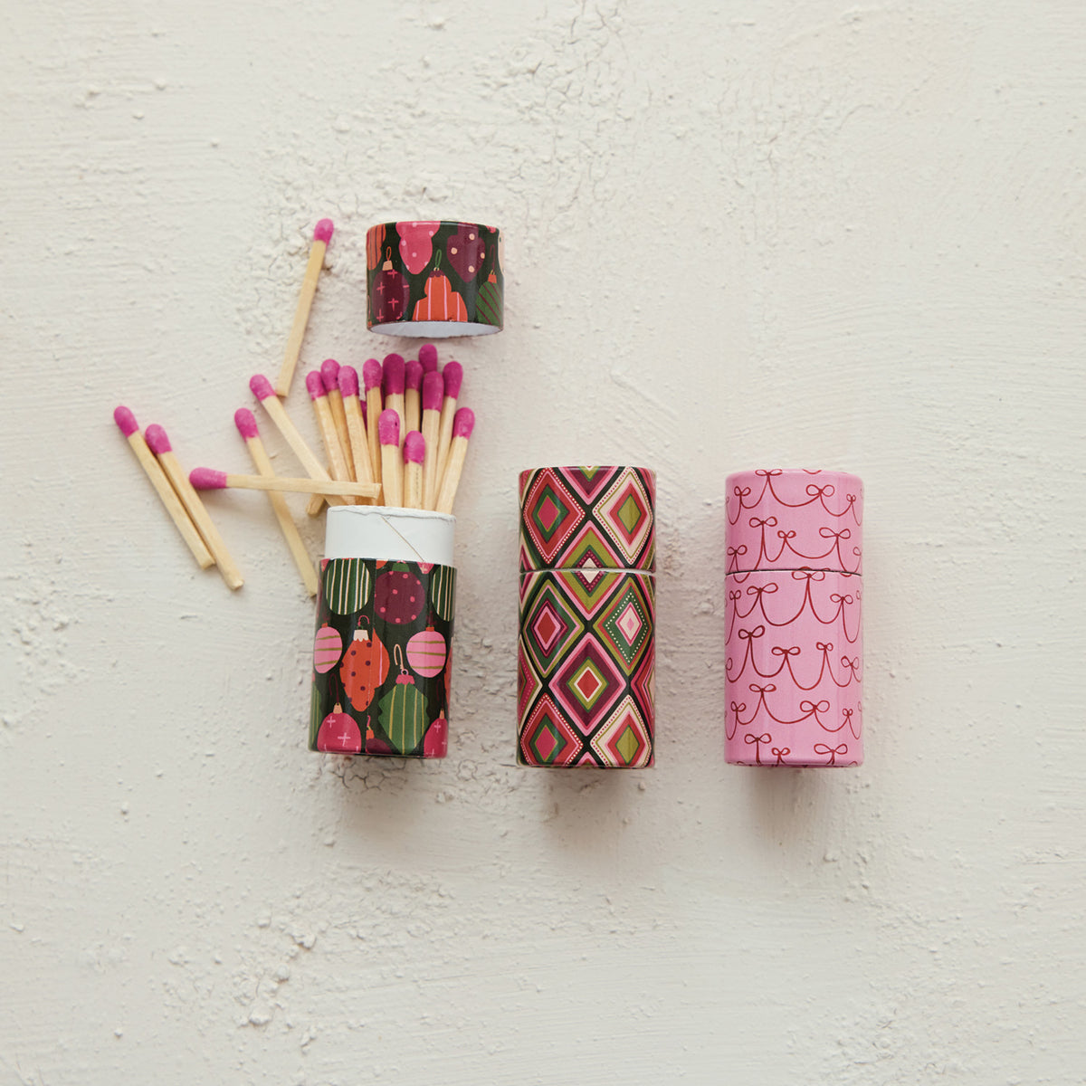 Bring cozy warmth and festive nostalgia to your home with these Retro Holiday Safety Matches. Packaged in charming matchbox tubes featuring festive patterns, they make lighting your favorite seasonal candles a delightful, comforting ritual.