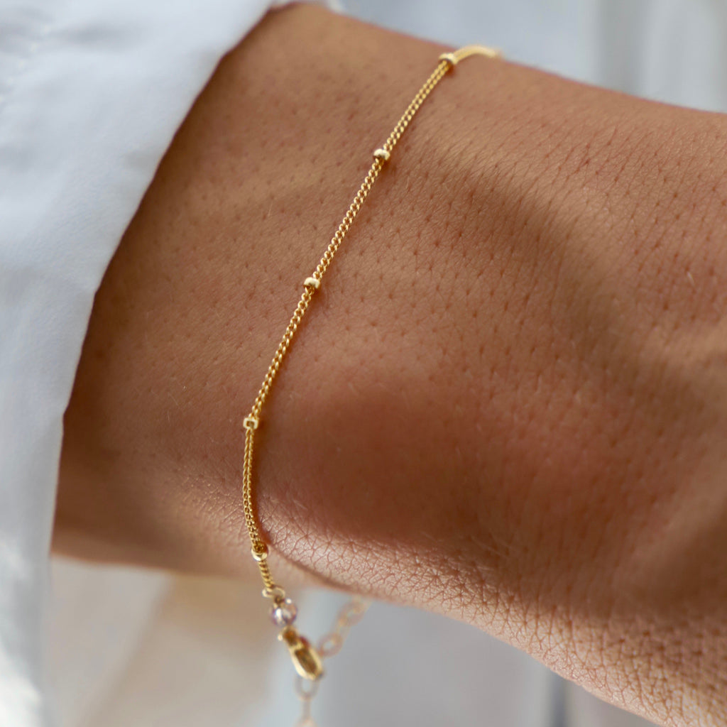 This dainty bracelet features a petite ball chain, perfect for adding a delicate touch to any outfit. Its lightweight design ensures comfortable wear, while its versatile style makes it suitable for any occasion. Dress it up or down for a touch of subtle elegance.