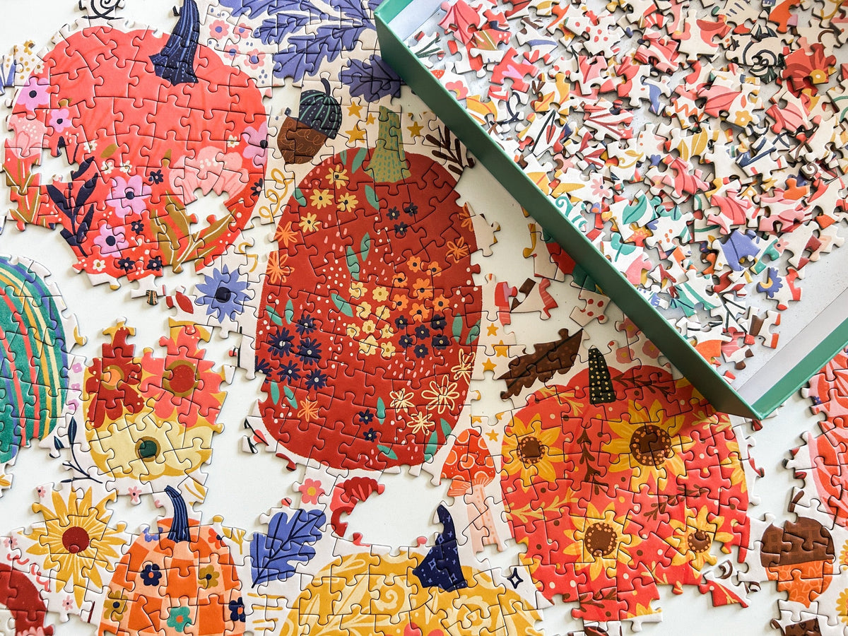Above view of patchwork pumpkins puzzle. Graphics done in a patchwork style. Lots of cheerful pumpkins with cute and quirky designs. 