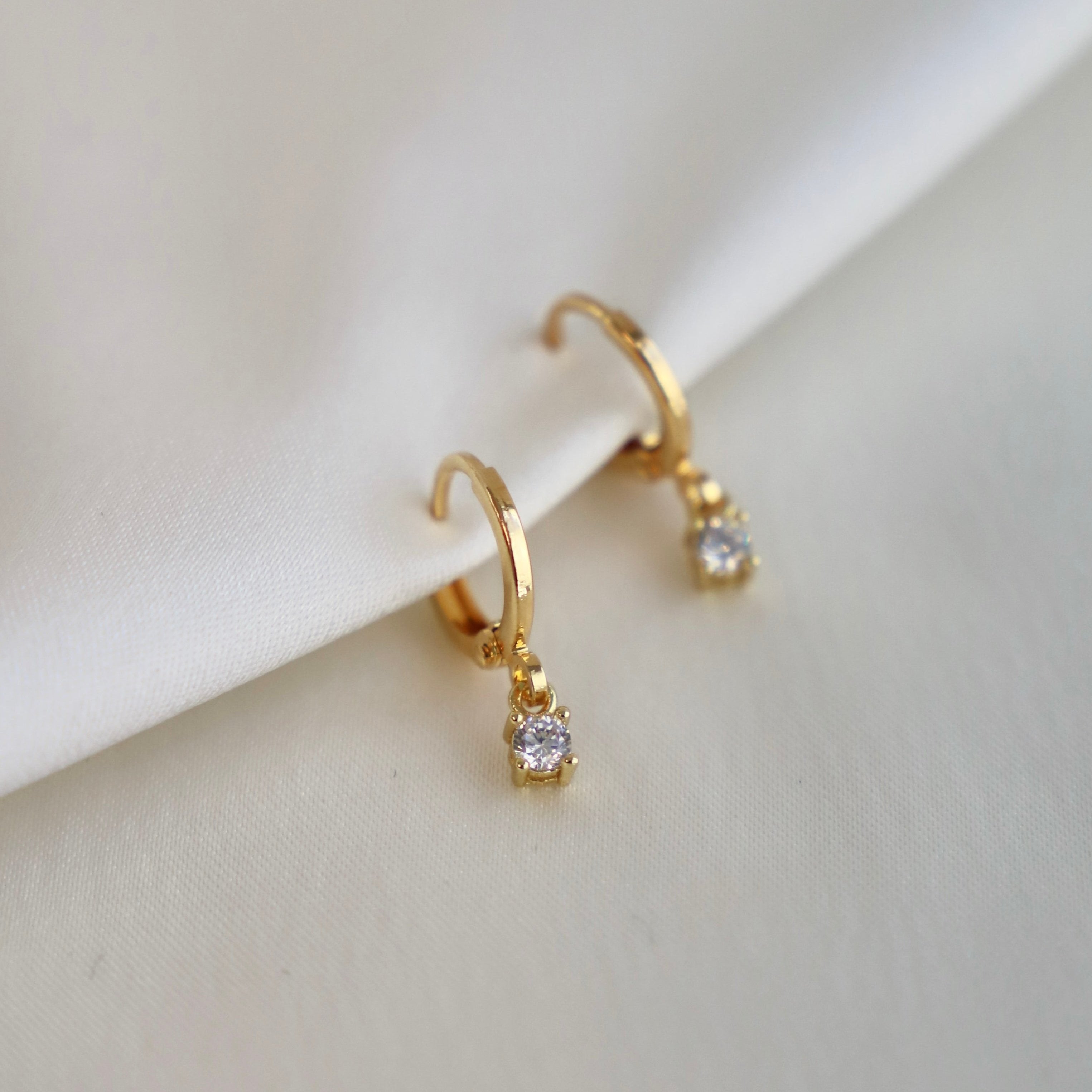 Sparkle all day with our Miniature CZ Drop Earrings! These huggie earrings feature delicate round cubic zirconia drops for a touch of elegance. Perfect for any occasion, these earrings will make you feel extra special.