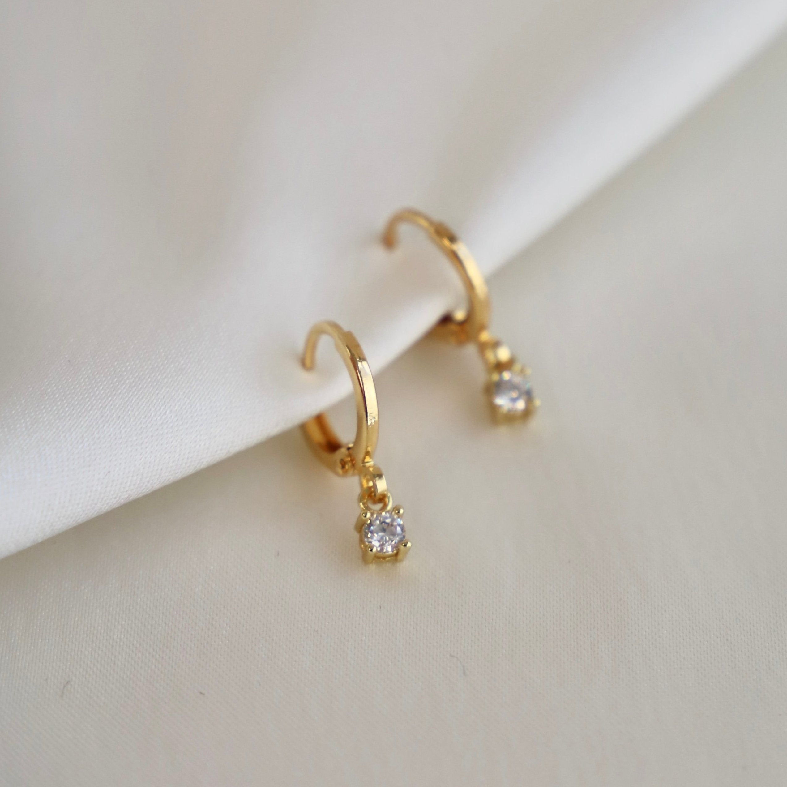 Sparkle all day with our Miniature CZ Drop Earrings! These huggie earrings feature delicate round cubic zirconia drops for a touch of elegance. Perfect for any occasion, these earrings will make you feel extra special.